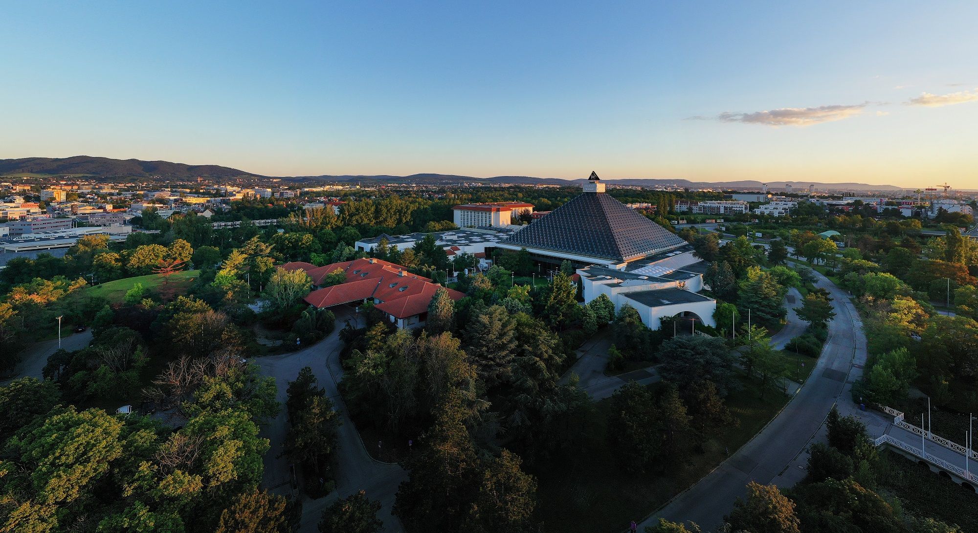 Az Eventhotel Pyramide és a környező táj légifelvétele naplementekor.