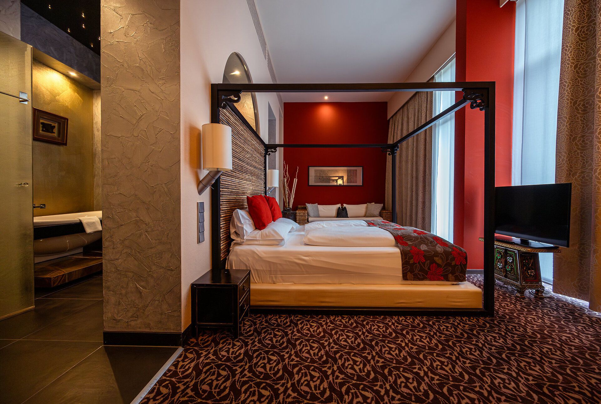 In einem stilvollen Zimmer mit warmen Farbtönen und einem gemütlichen Bett lädt die Atmosphäre zum Entspannen ein. Die harmonische Einrichtung und der Blick auf die umliegende Natur schaffen einen perfekten Rückzugsort für Erholungssuchende.