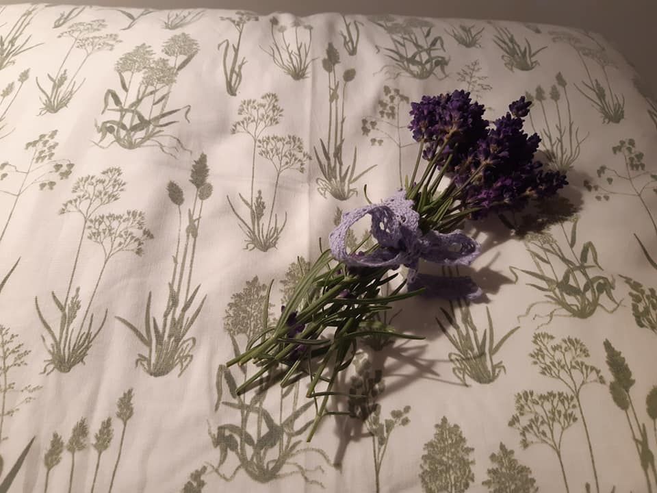 Egy csokor levendula fekszik egy növénymintás párnán.
