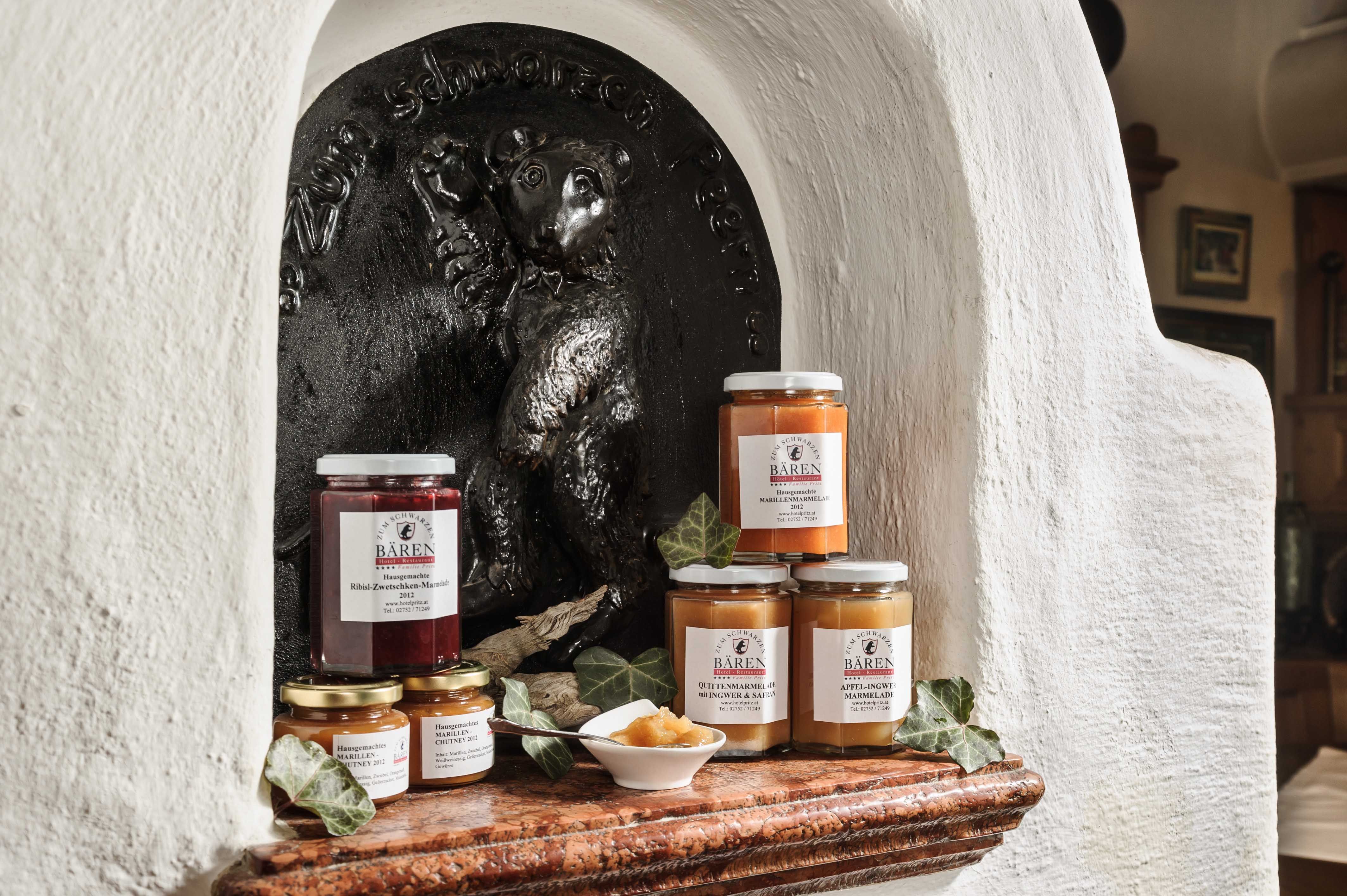 Különböző lekvárosüvegek egy medve dombormű előtt