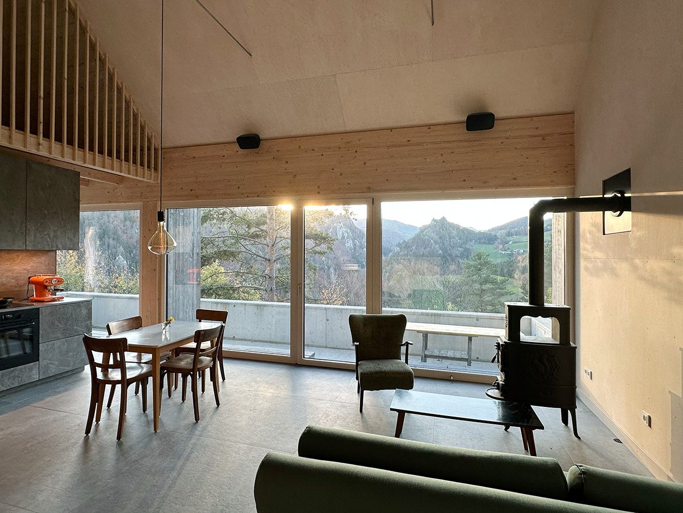 Modern nappali és étkező nagy ablakokkal és hegyi kilátással.