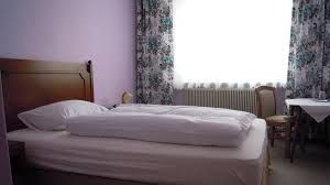 Egyszerűen berendezett szállodai szoba ággyal, asztallal és székkel.