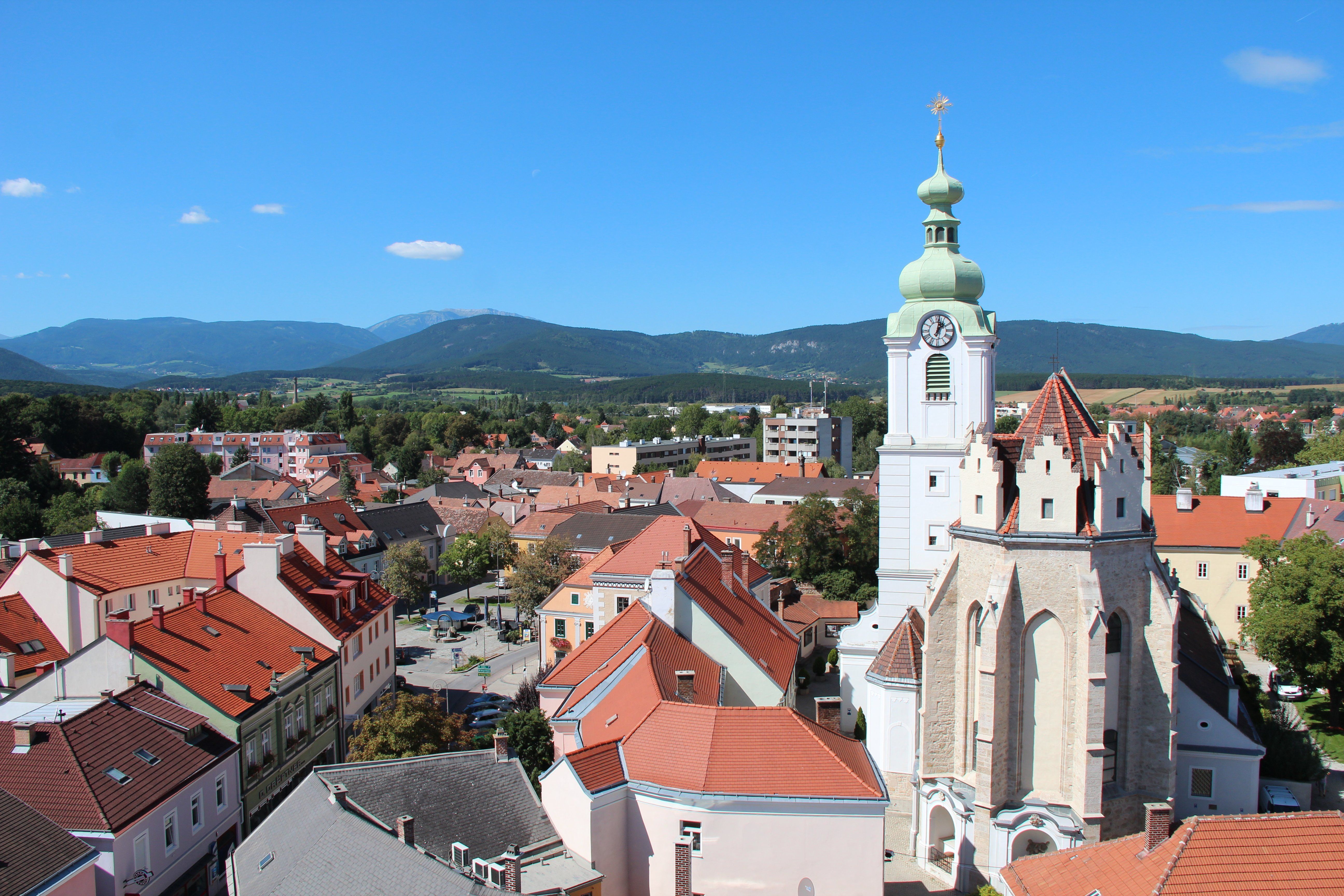 Neunkirchen panorámaképe, háttérben a templom és a hegyek.
