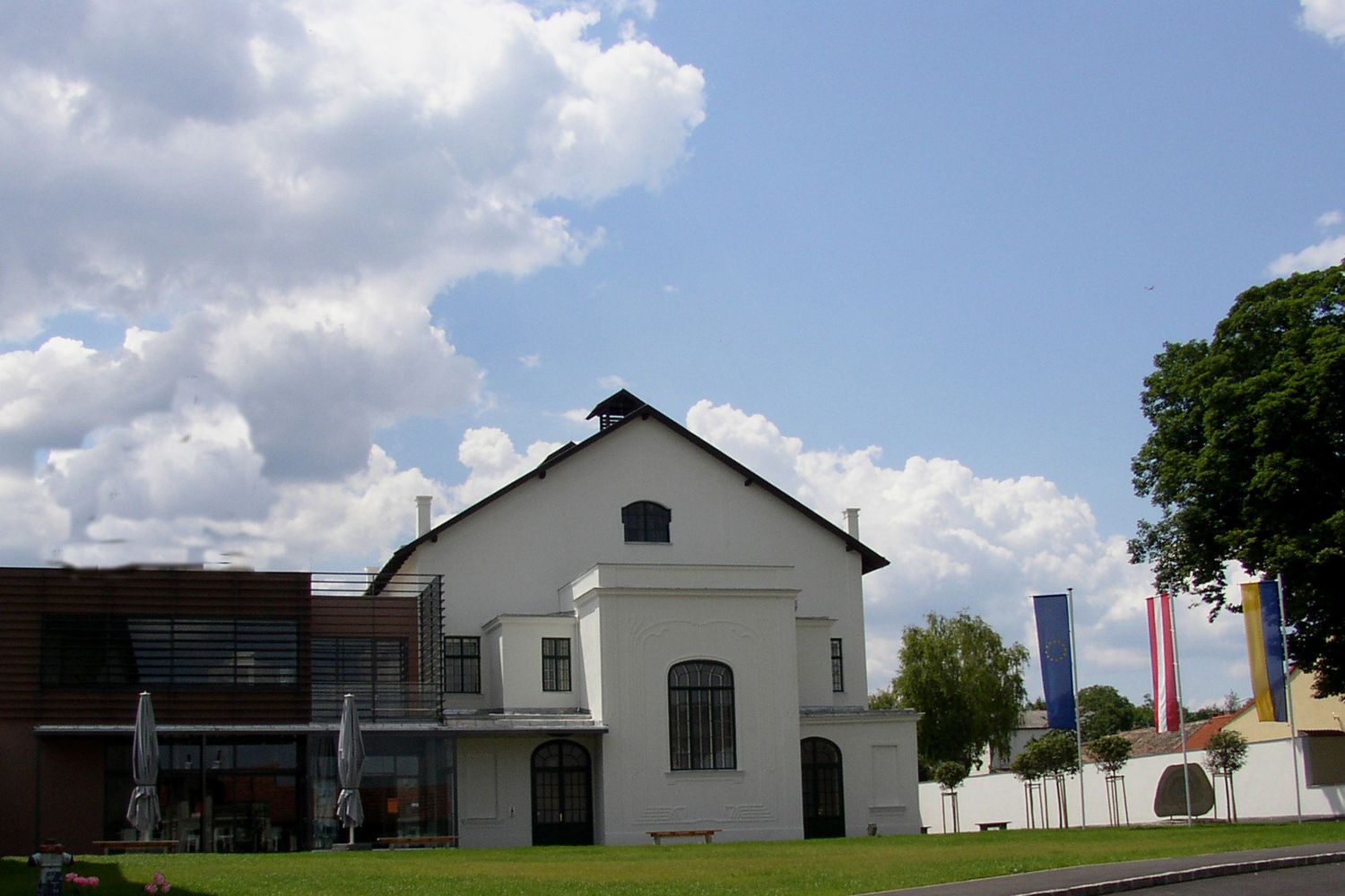 Ziersdorf koncertterem modern bővítéssel és zászlókkal az előtérben.