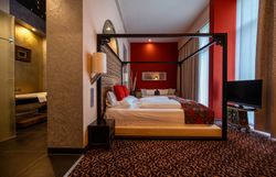 In einem stilvollen Zimmer mit warmen Farbtönen und einem gemütlichen Bett lädt die Atmosphäre zum Entspannen ein. Die harmonische Einrichtung und der Blick auf die umliegende Natur schaffen einen perfekten Rückzugsort für Erholungssuchende.