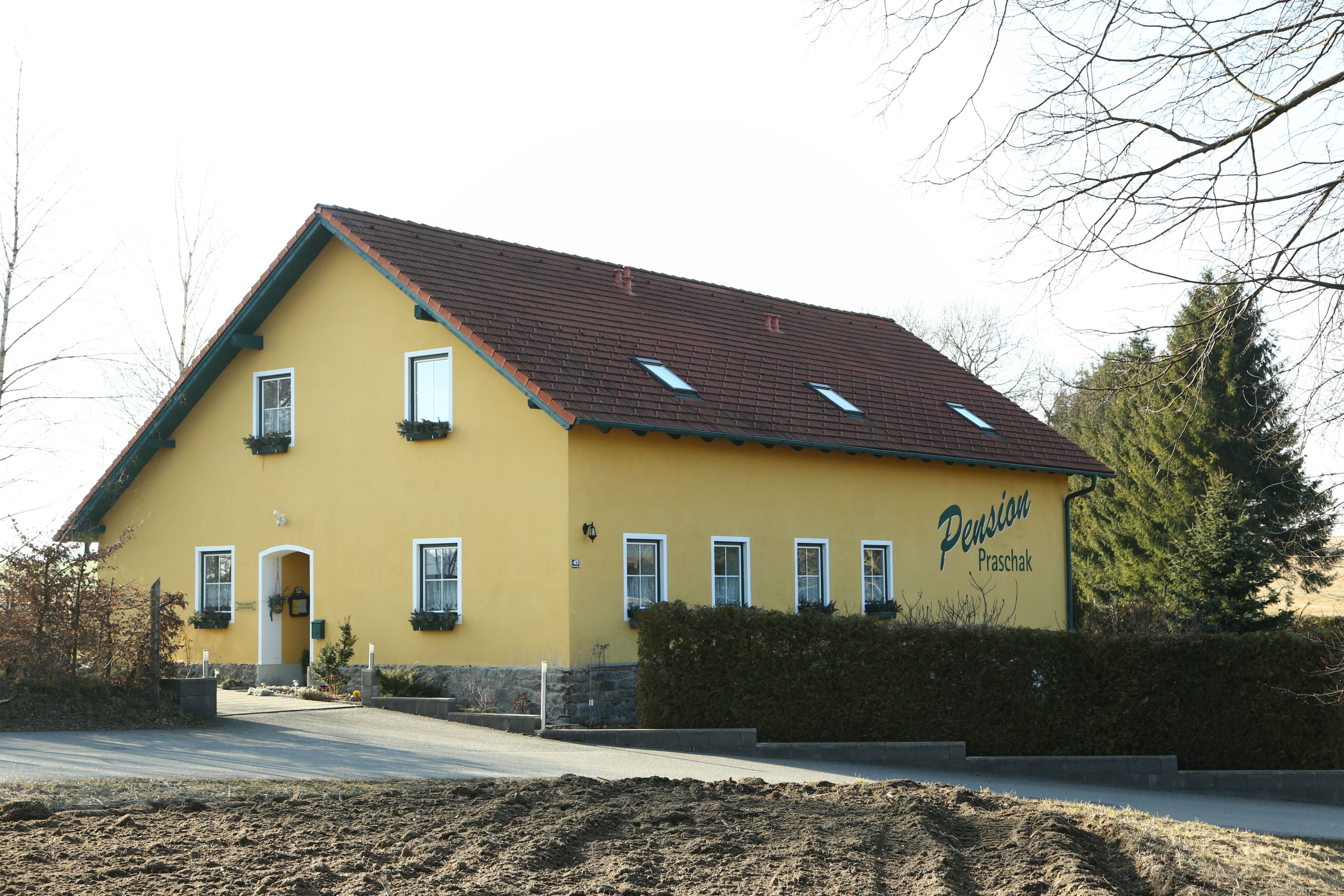 Sárga színű épület "Praschak panzió" felirattal.
