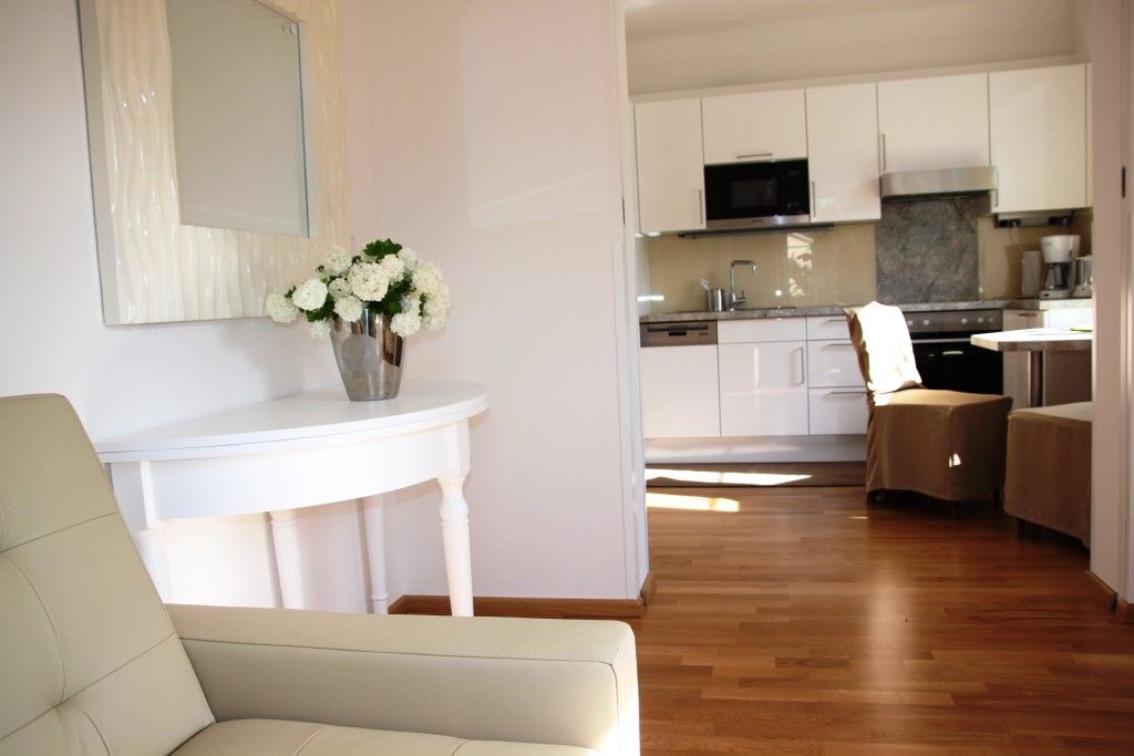 Egy modern nappali belső nézete konyhával és virágokkal az asztalon.