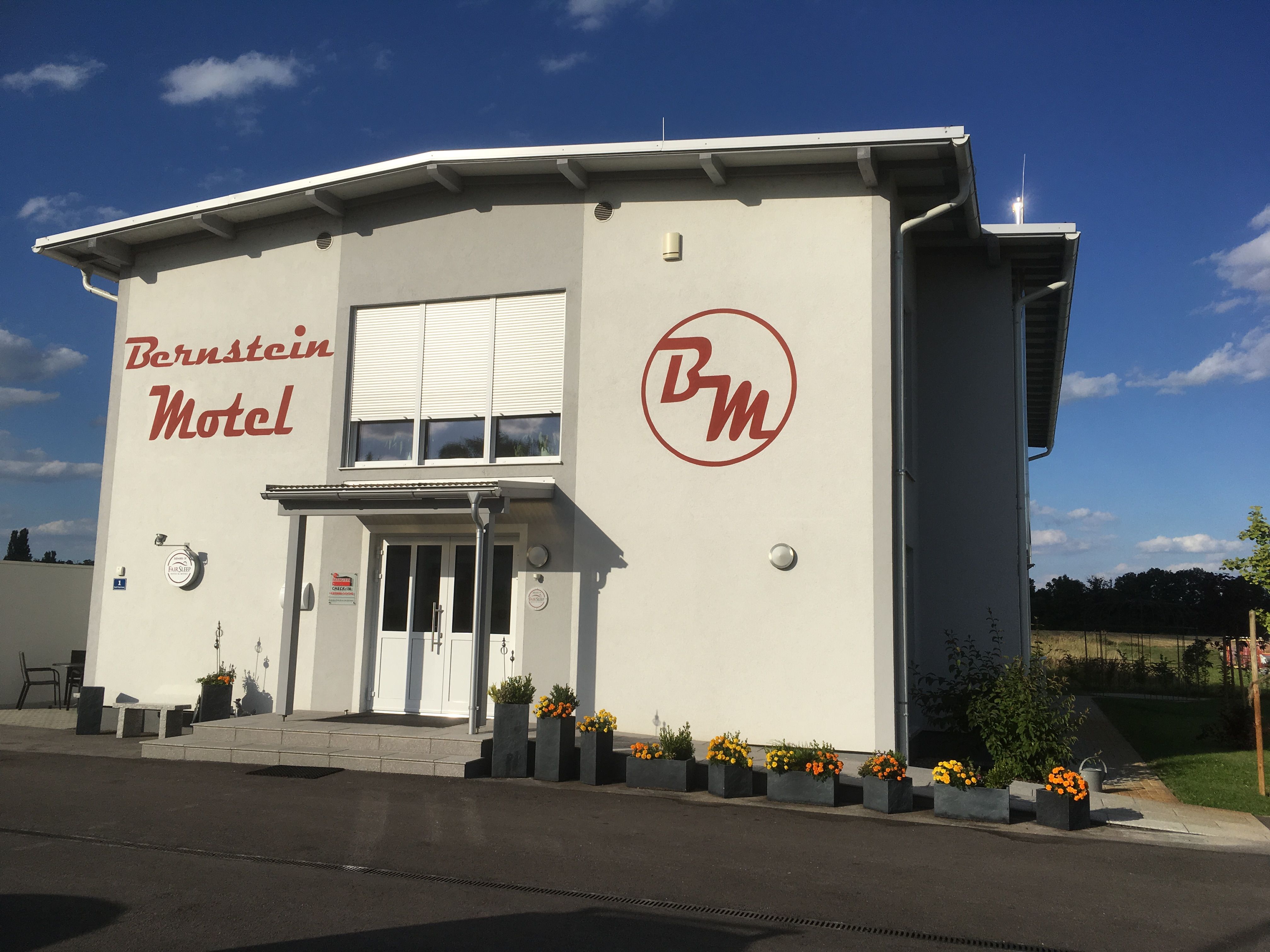 A Bernstein Motel külső nézete virágokkal és kék éggel.