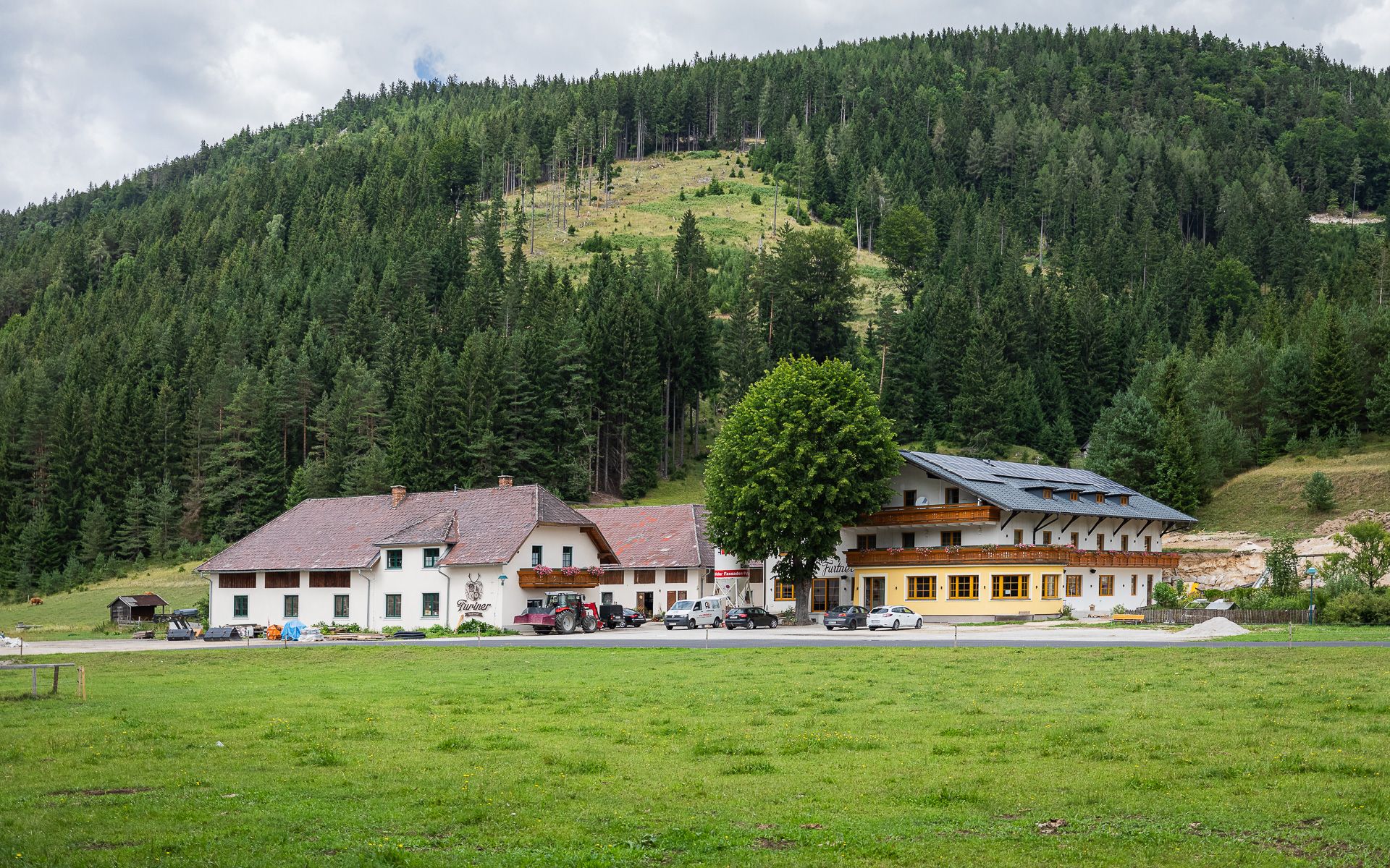 Gasthof Furtner egy erdős domb előtt.