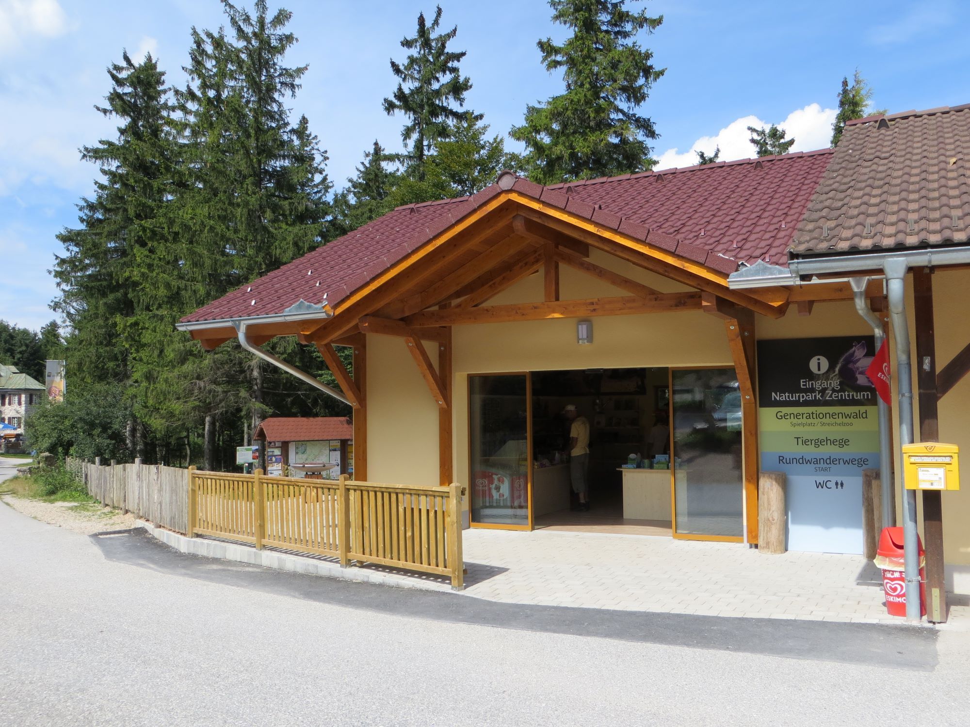 A natúrpark bejárata fából készült verandával és információs táblával.