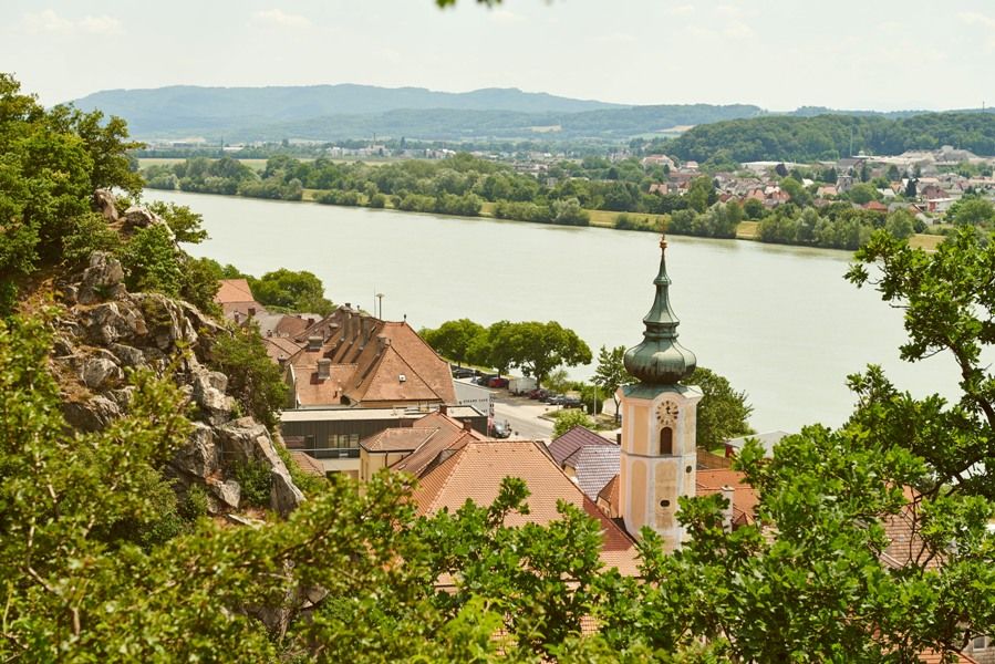 Marbach látképe a Dunán, nyáron, templommal és a folyóval.