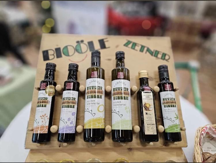 Öt üveg bioolaj a "Bioöle Zeiner" feliratú faállványon.
