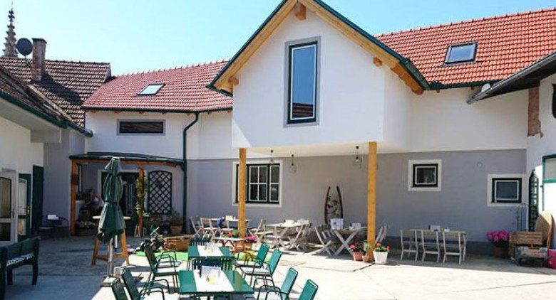 Egy fogadó belső udvara, kint asztalokkal és székekkel.