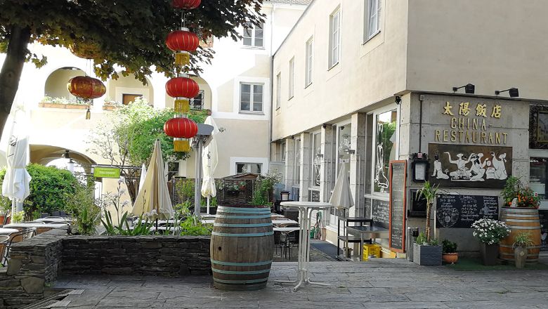 Kínai étterem piros lámpásokkal és szabadtéri területtel.