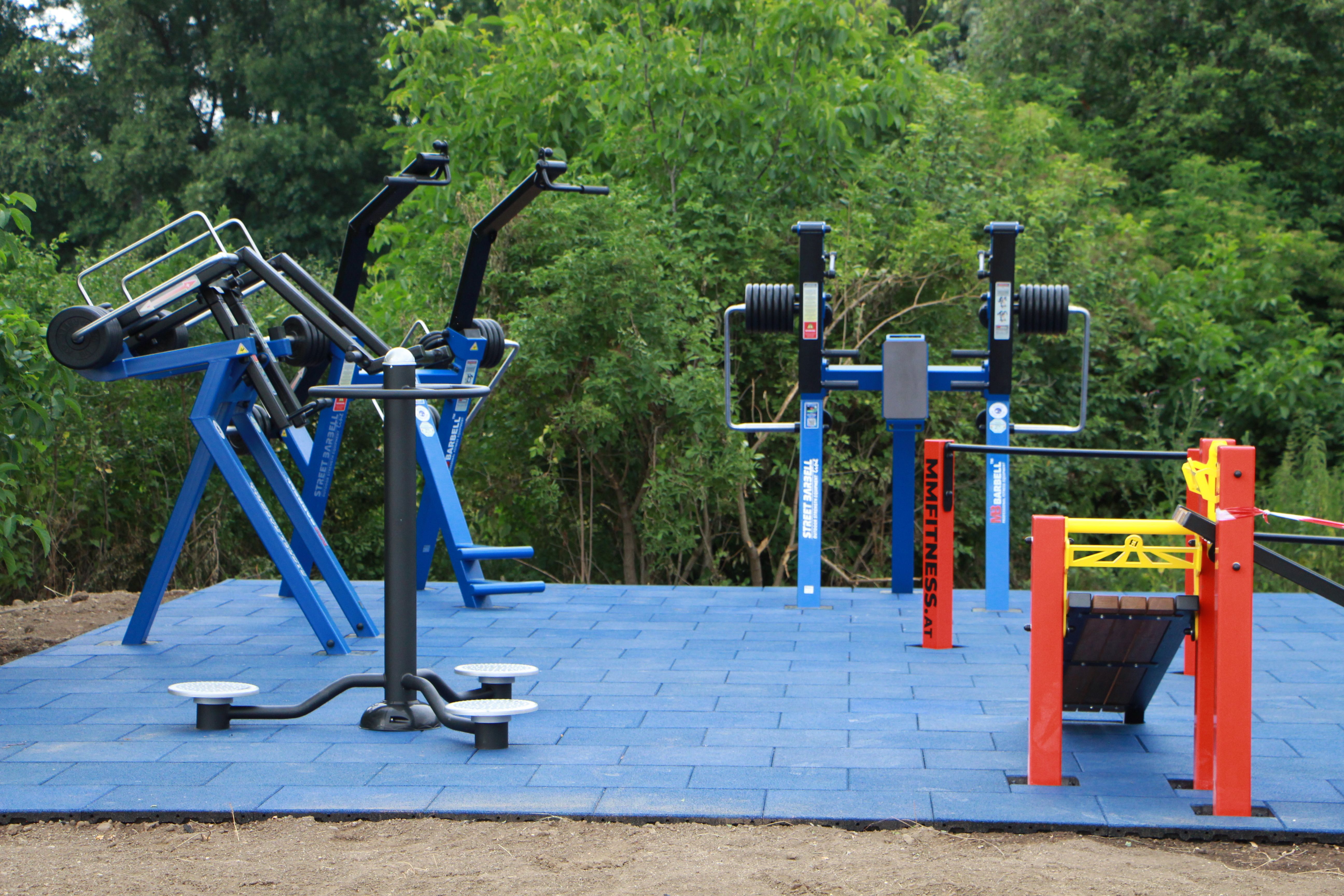 Kültéri fitneszeszközök kék kültéri padlólapokon.