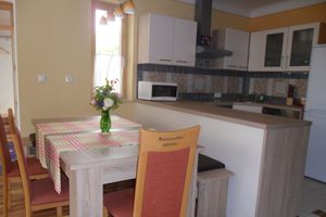 Modern konyha és étkező asztalokkal, székekkel és konyhai eszközökkel.