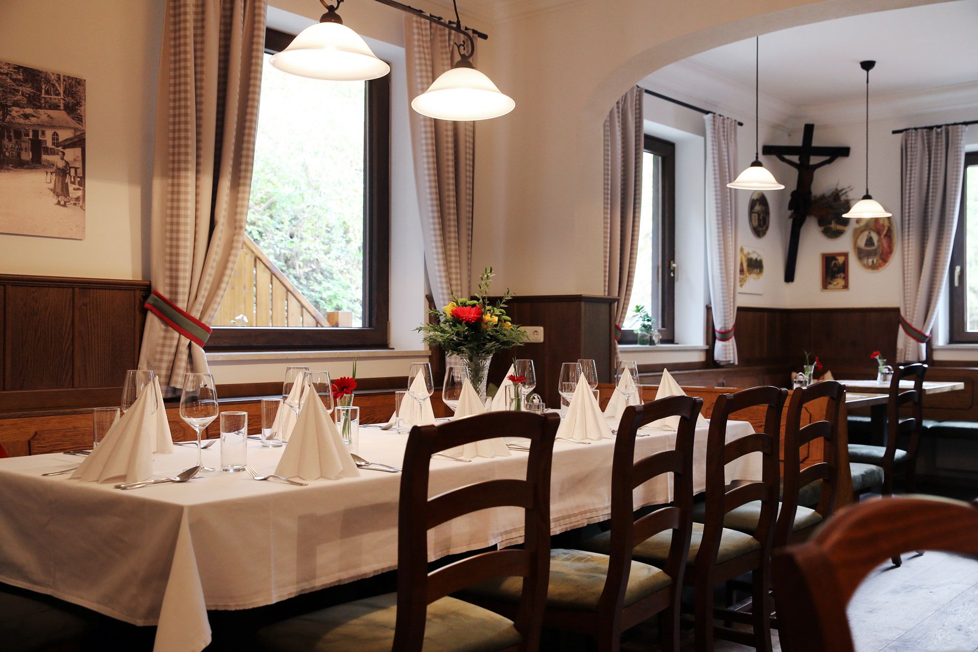 Egy hangulatos vendéglő belső tere terített asztallal, fabútorokkal és díszítésekkel a falakon.