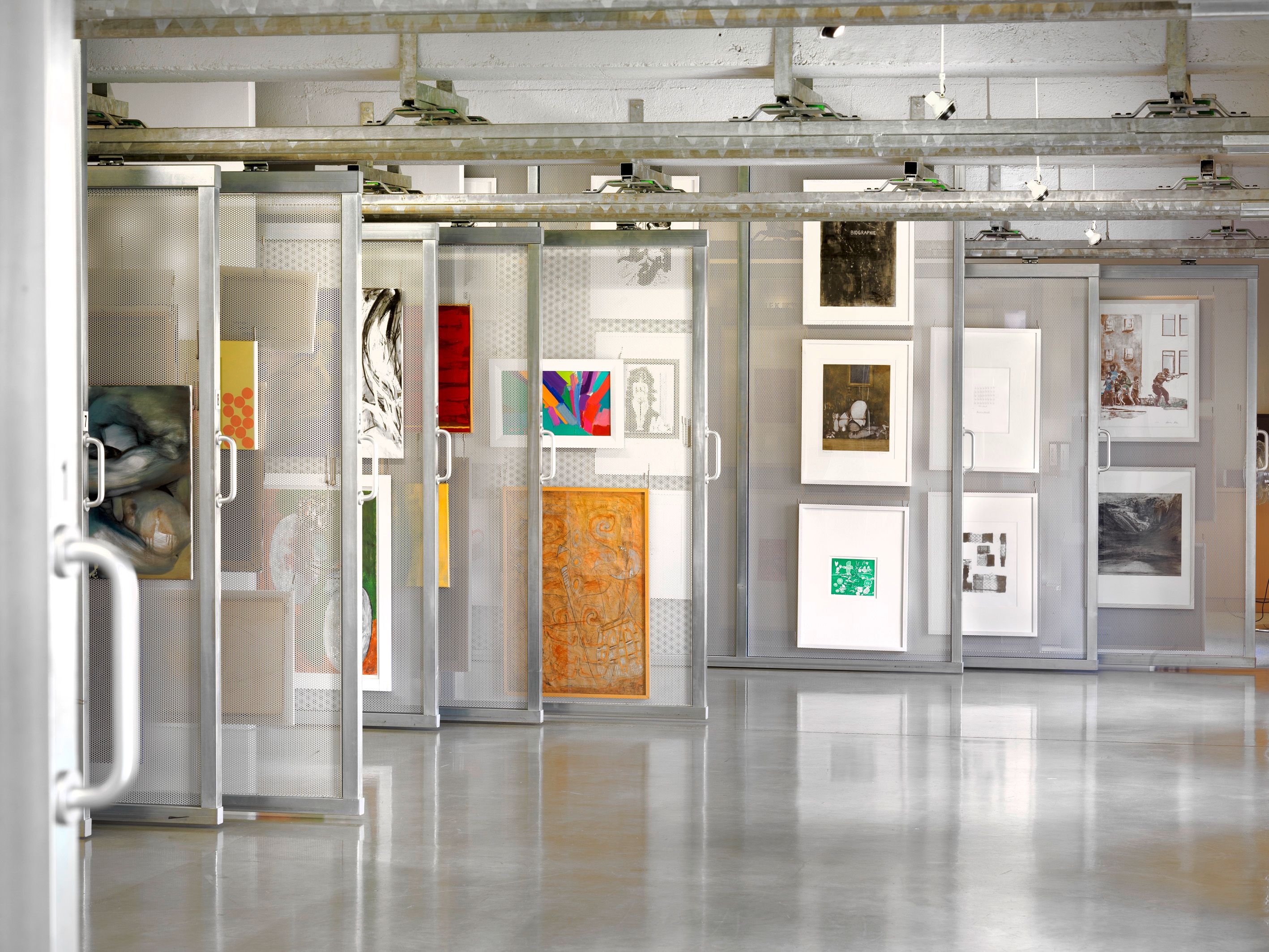 Egy művészeti könyvtár belső nézete, mozgatható polcokon elhelyezett műtárgyakkal.