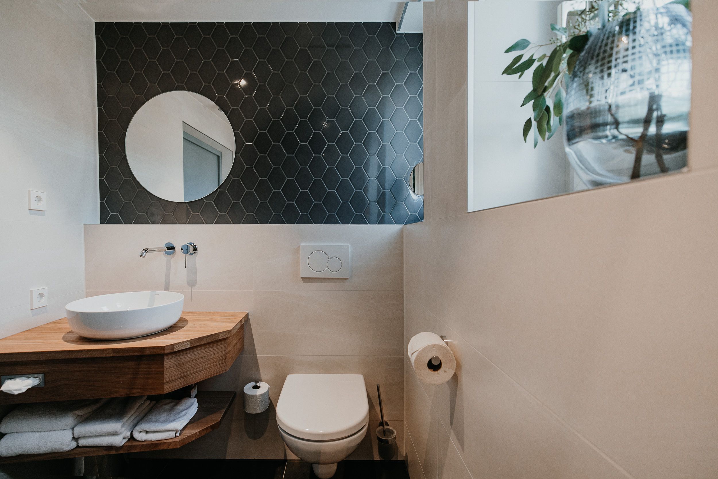 Modern fürdőszoba mosdóval, tükörrel és WC-vel.