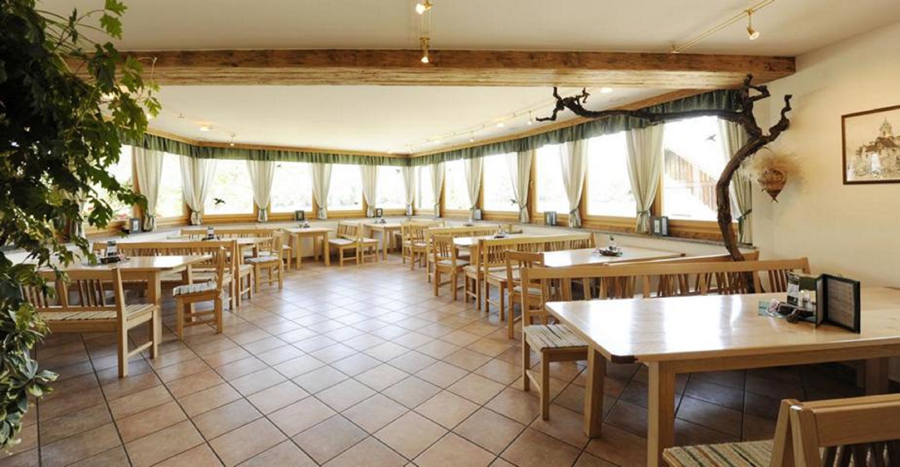 Egy borozó belső nézete, fa bútorokkal és nagy ablakokkal.