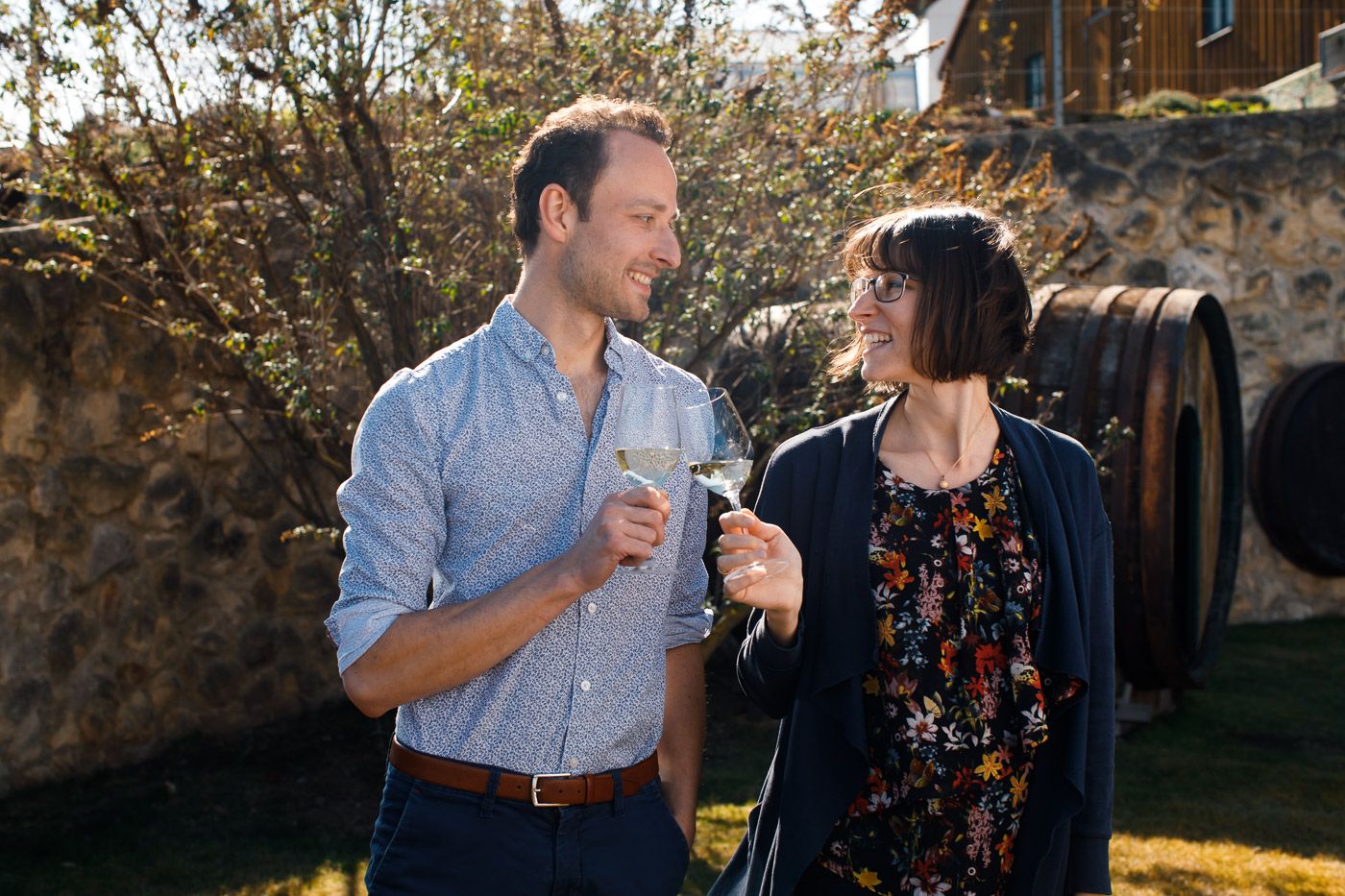 Egy férfi és egy nő kint koccintanak a borospoharakkal.