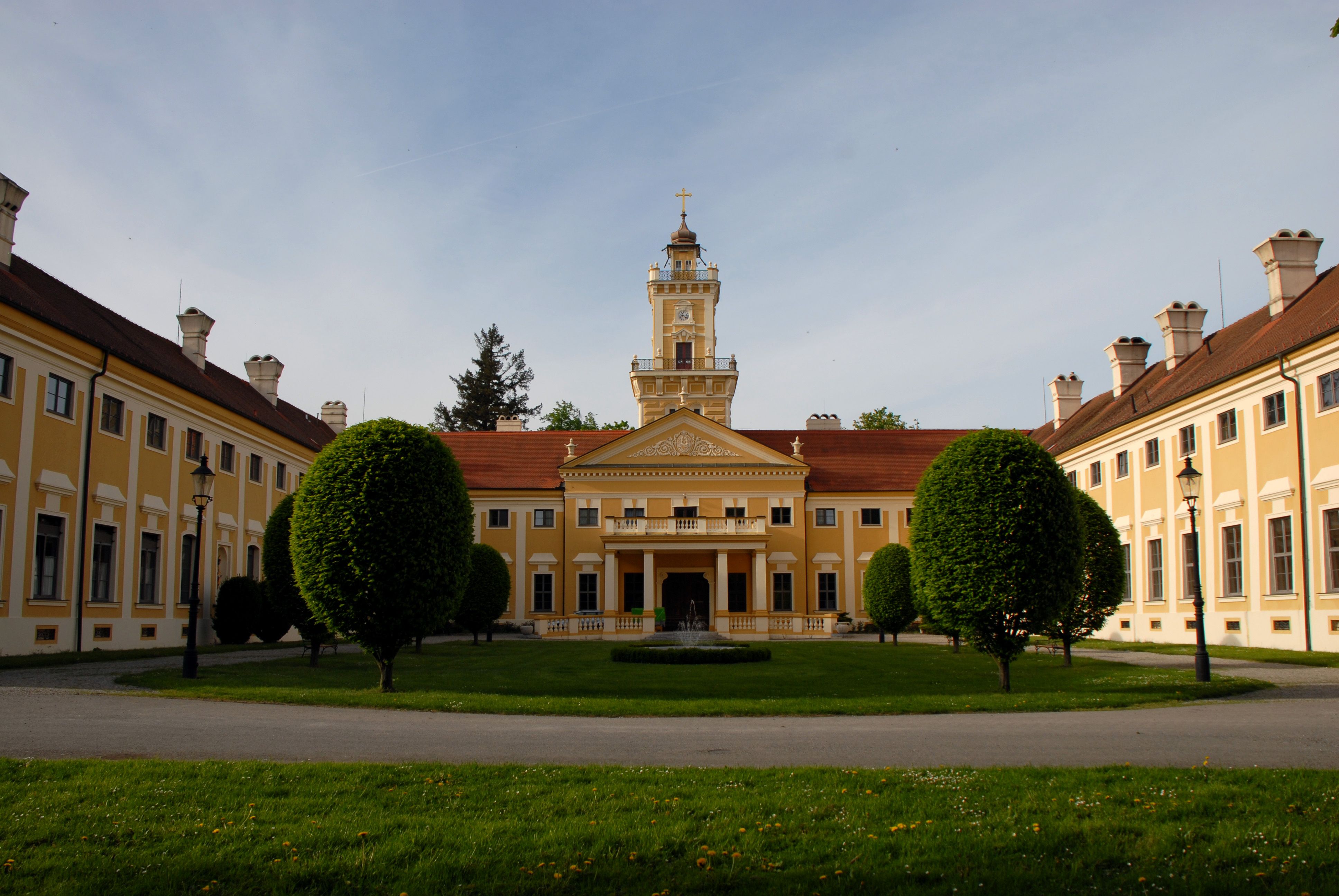 Jaidhof kastély sárga homlokzatával és tornyával, melyet gondozott kert vesz körül.