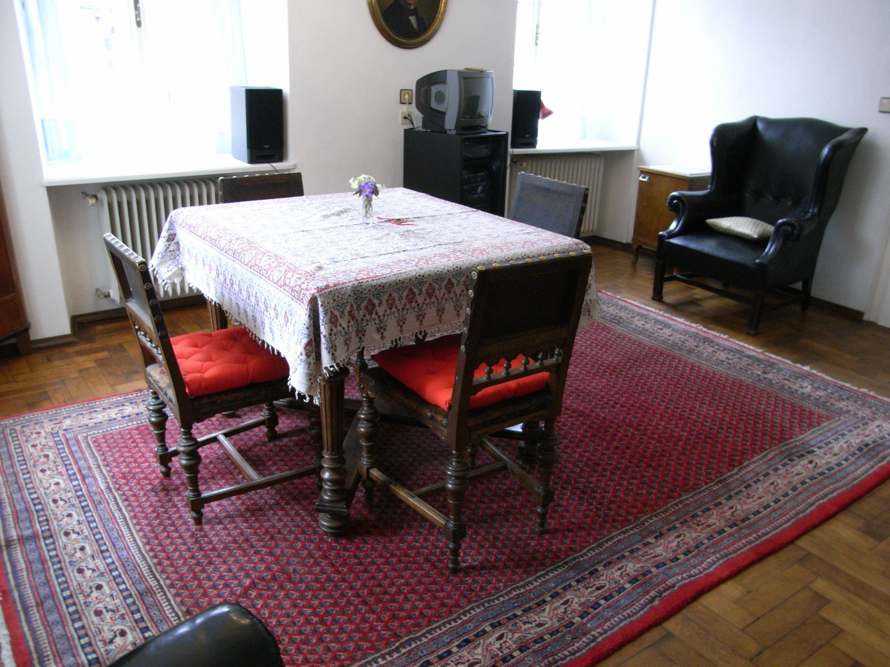 Nappali asztallal, székekkel és szőnyeggel.