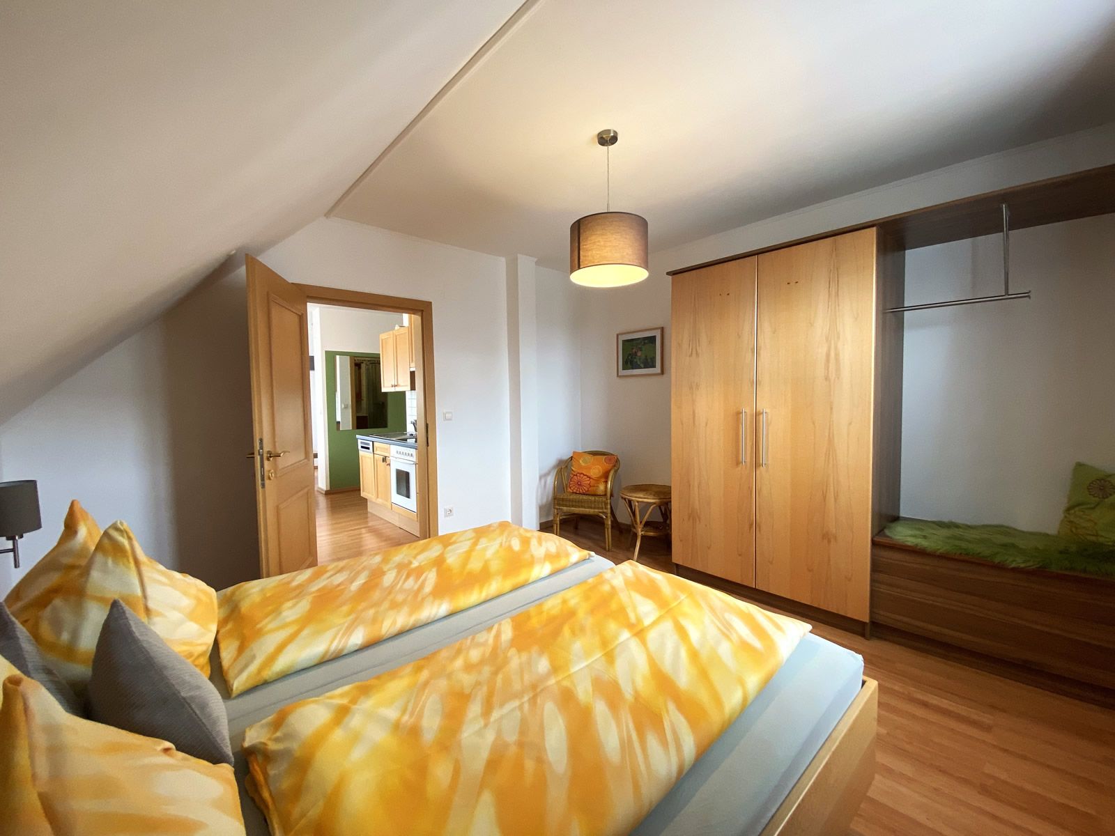 Hálószoba franciaággyal, szekrénnyel és kilátással a konyhára.