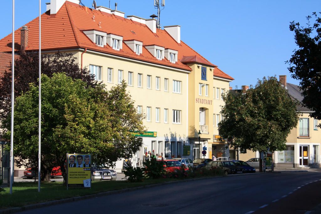 Ebenfurth városháza a környező épületekkel és fákkal.