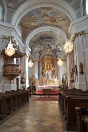 Egy barokk templom belső nézete oltárral, szószékkel és csillárokkal.