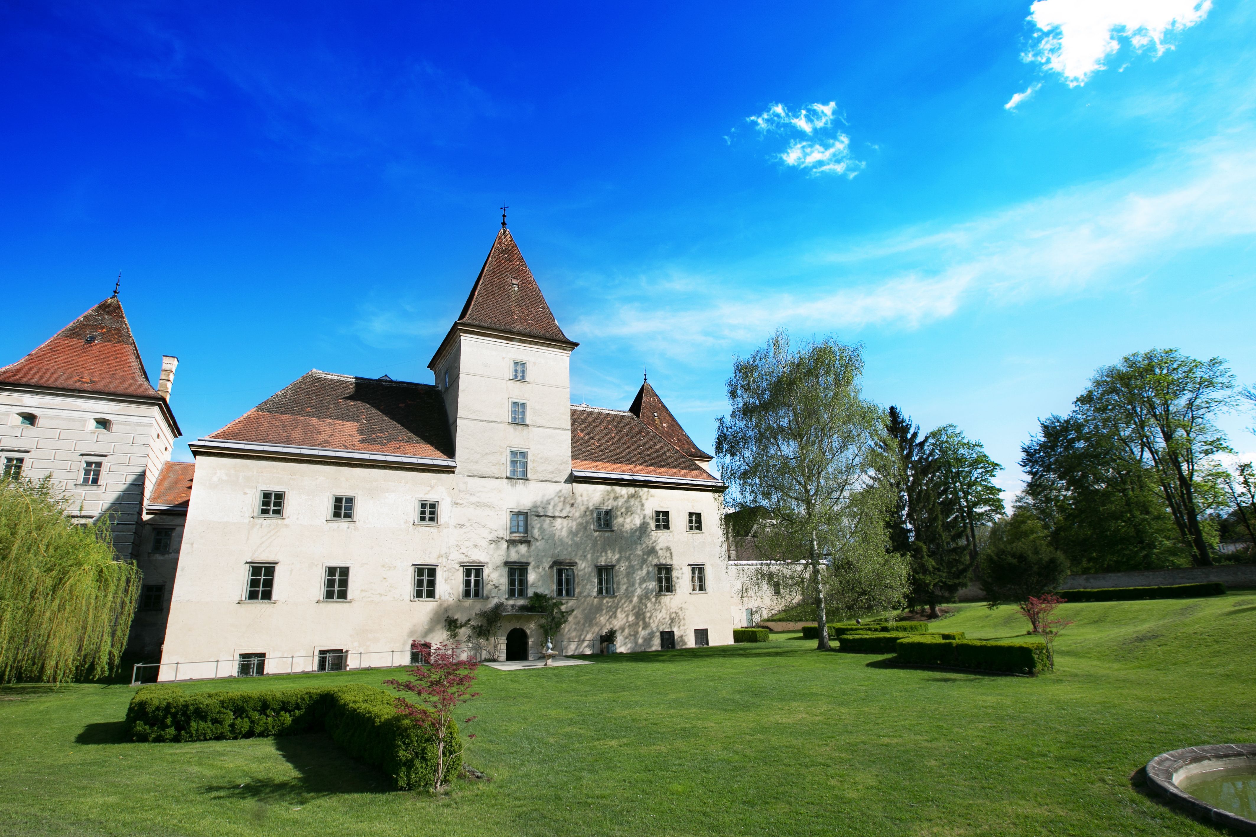 Walpersdorf kastély kert és kék égbolt.