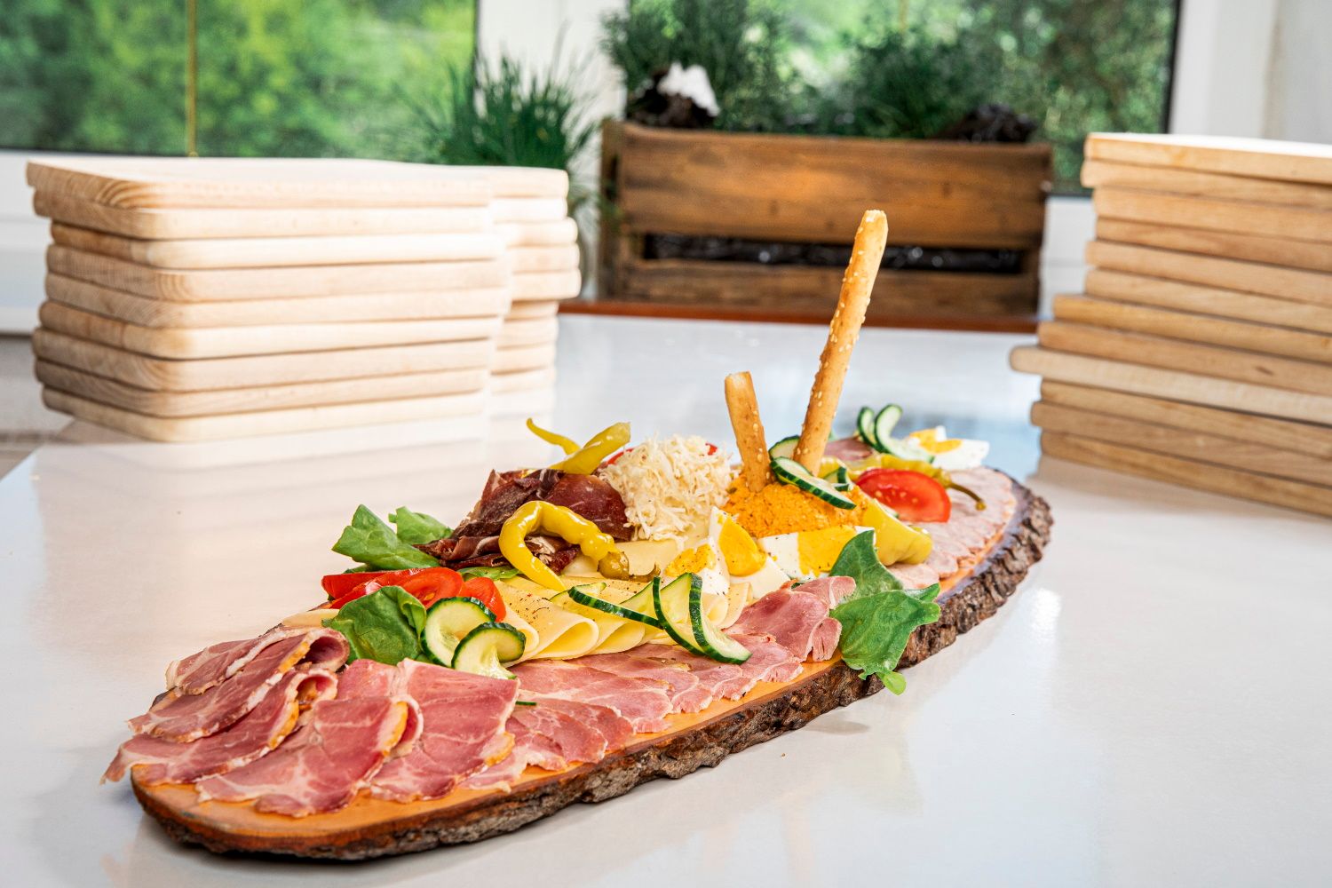 Heurigen tál sonkával, sajttal, zöldségekkel és kenyérszeletekkel rusztikus fatáblán.