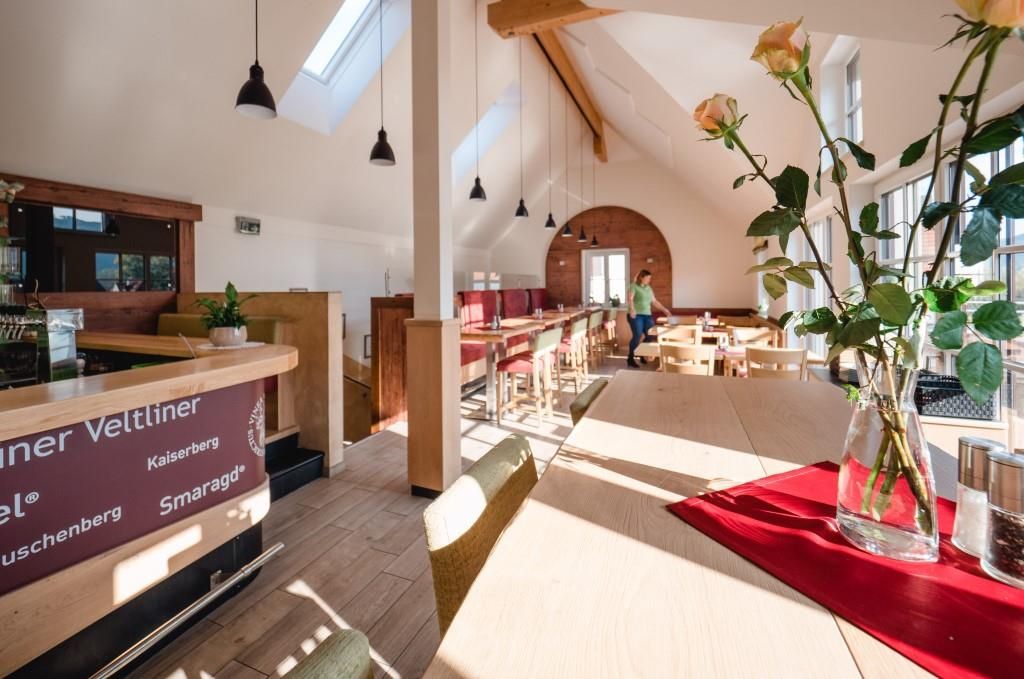 Egy hagyományos borozó belső nézete, fa bútorokkal és nagy ablakokkal.