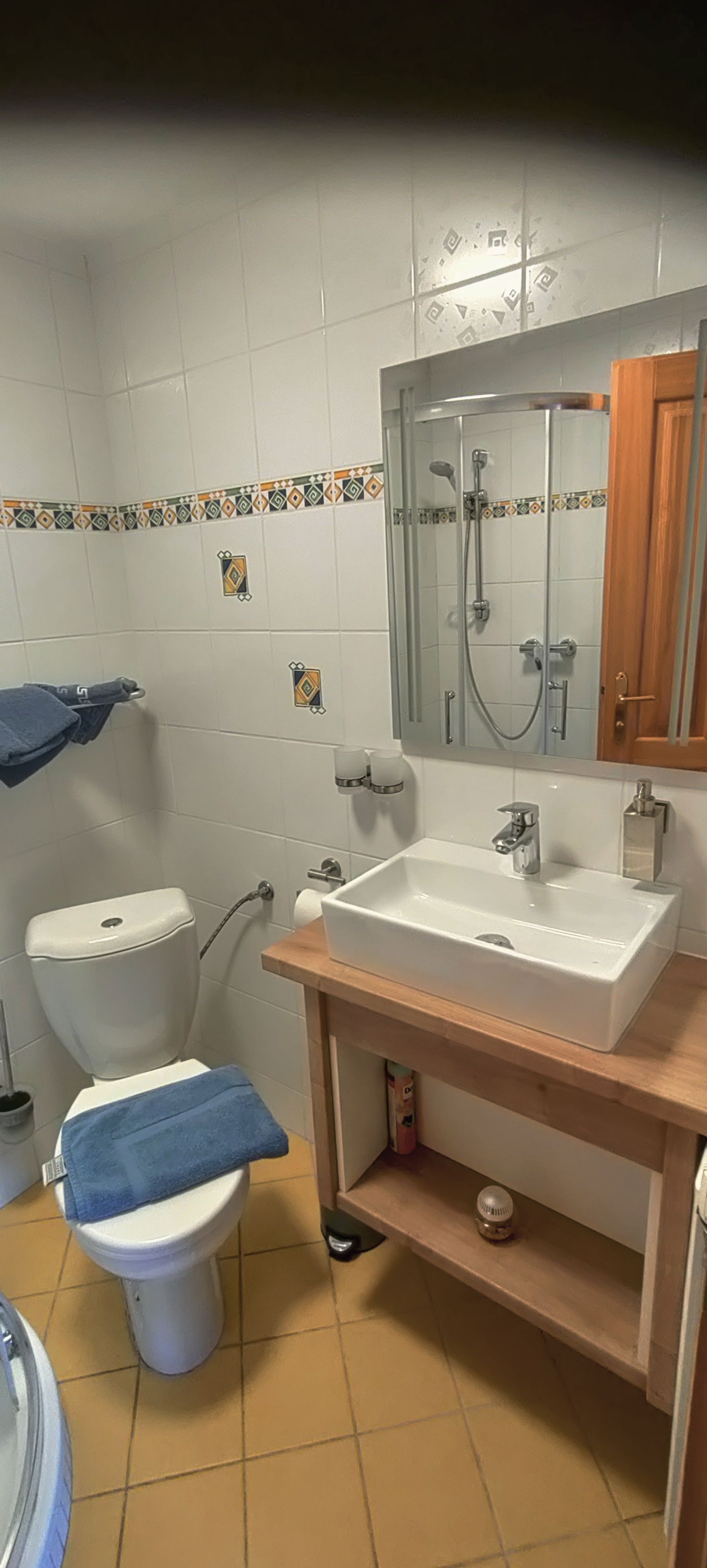 Kis fürdőszoba WC-vel, mosdóval és tükörrel.