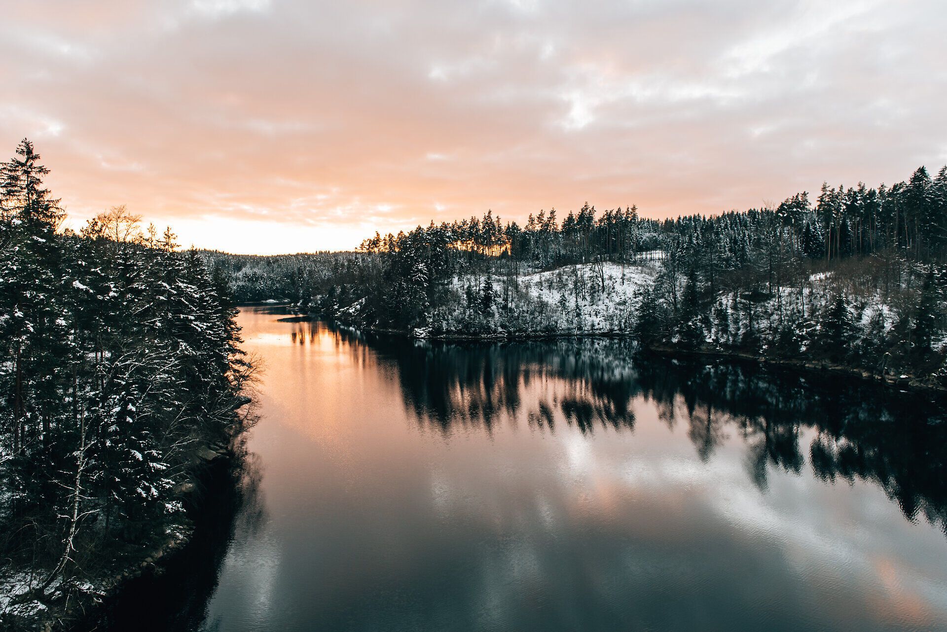 A víztározó szelíd hullámai visszatükrözik a hóval borított partokat, miközben a lenyugvó nap meleg színekkel világítja meg az eget. Békés csend veszi körül a tájat, amely elidőzésre és pihenésre hívja Önt.
