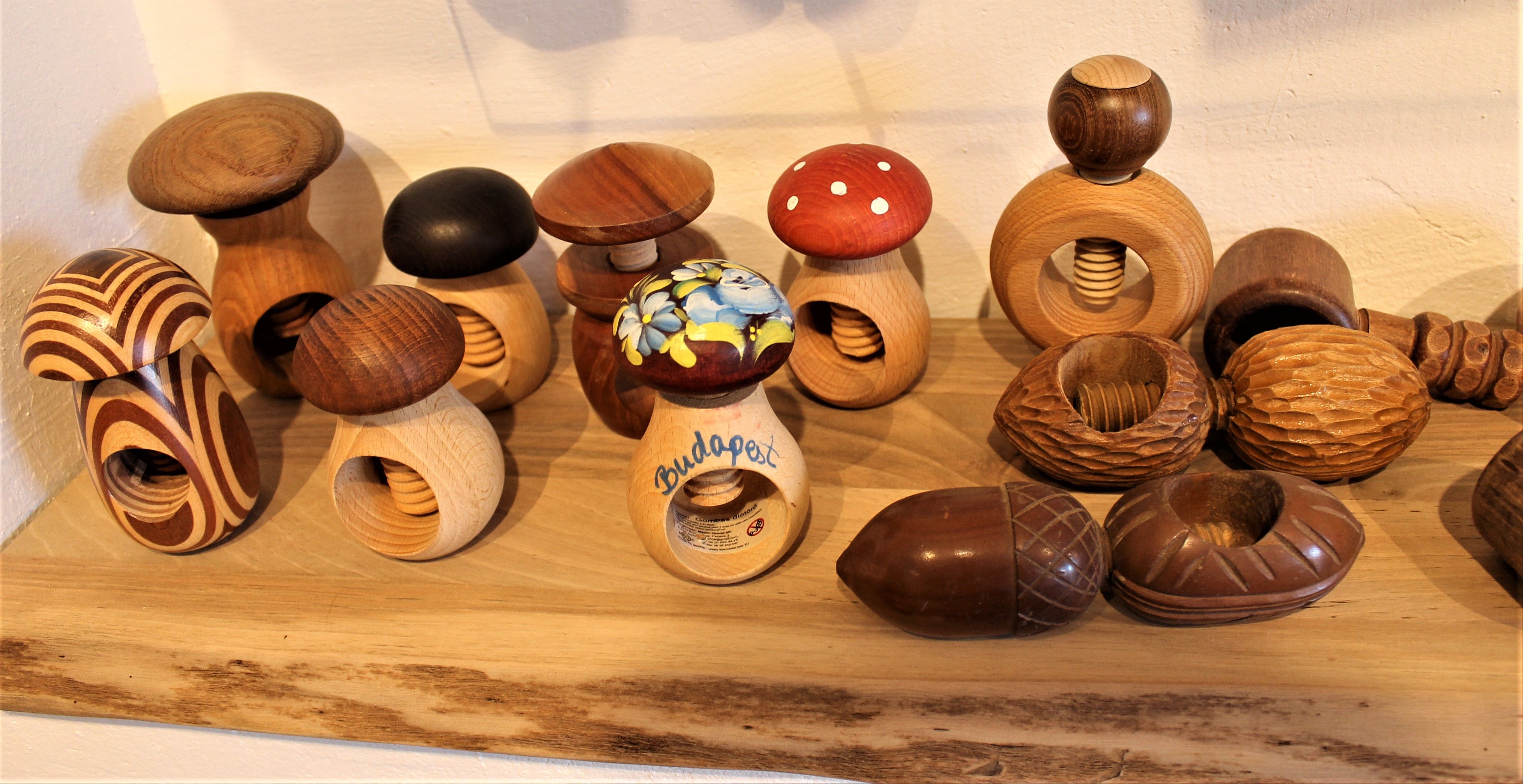 Különböző gomba alakú fa diótörők egy polcon a Nusseum Krummnußbaumban.