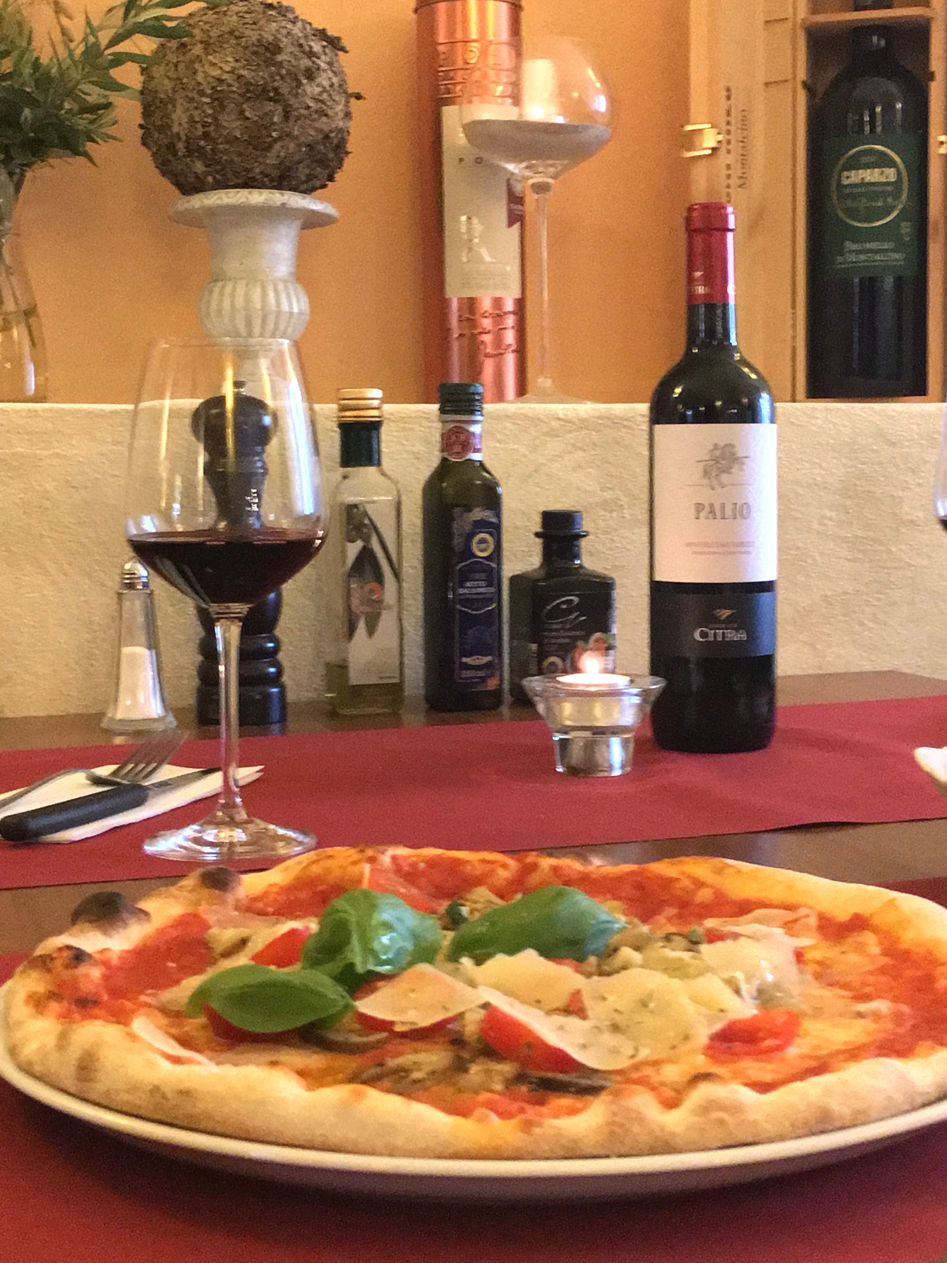 Bazsalikomos és parmezános pizza vörösborral és olívaolajjal.