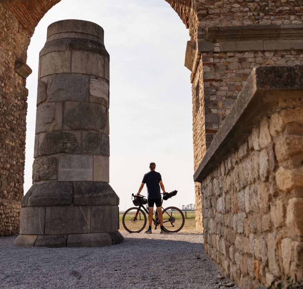 Ein Radfahrer genießt die majestätische Kulisse des Heidentors, während die warmen Sonnenstrahlen die alten Steine umspielen. Die sanfte Brise und die malerische Landschaft laden dazu ein, die Schönheit der Natur in vollen Zügen zu erleben.