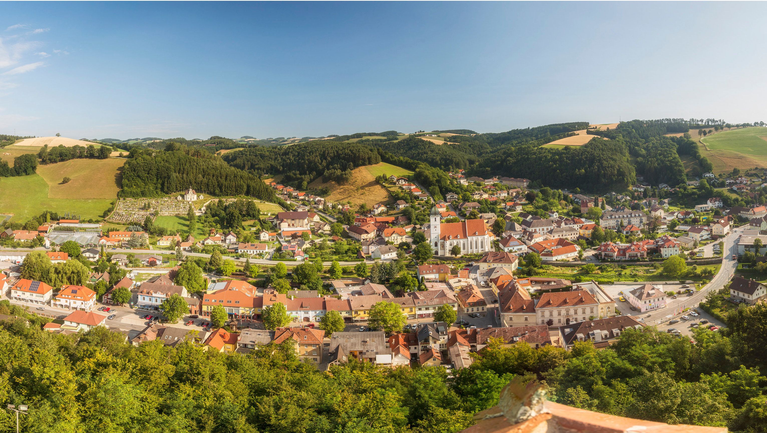 Kirchschlag in der Bucklige Welt panorámaképe a templommal és a környező dombokkal.