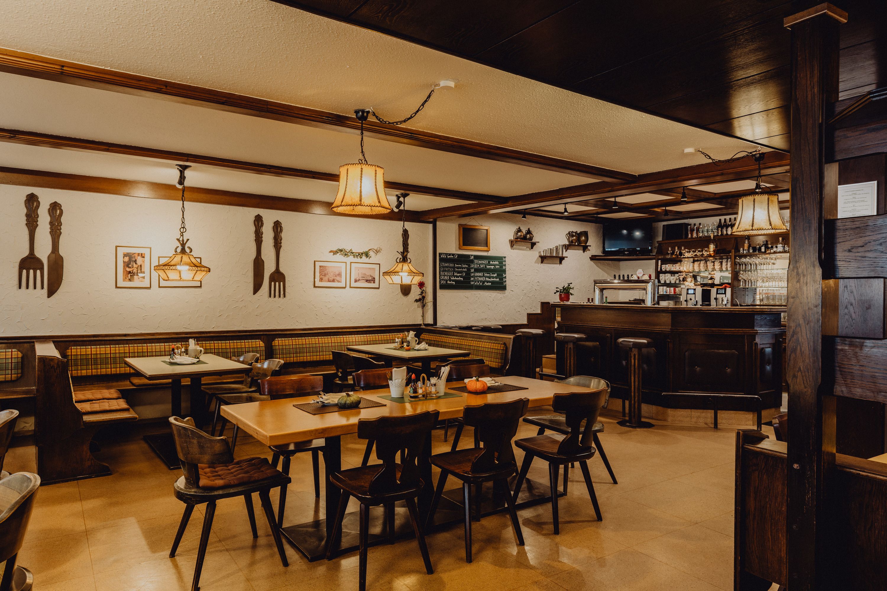 Hangulatos kocsma fabútorokkal, bárpulttal és dekoratív lámpákkal.