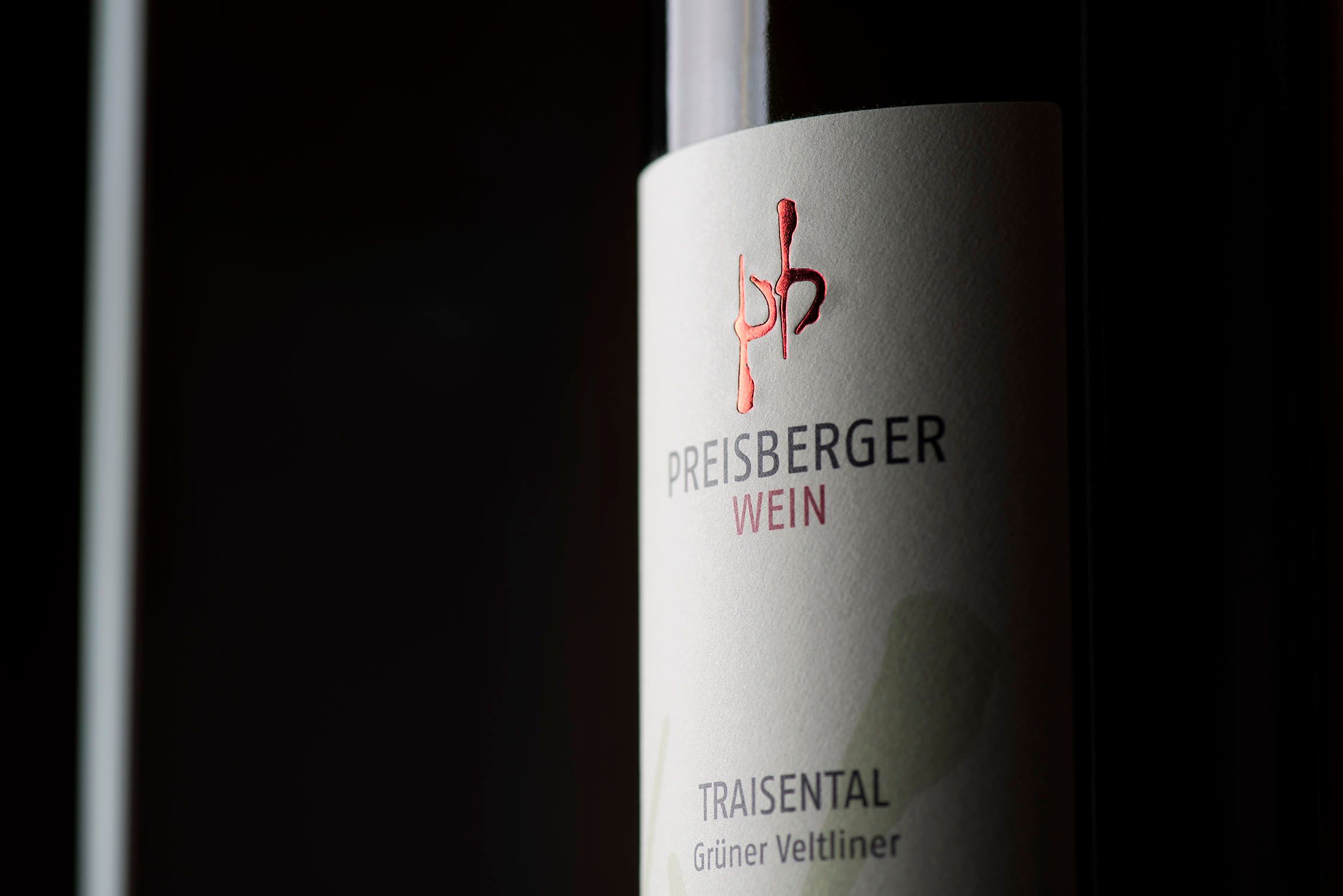 Közelkép egy borosüveg címkéjéről a "Preisberger Wein, Traisental, Zöldveltelini" felirattal.