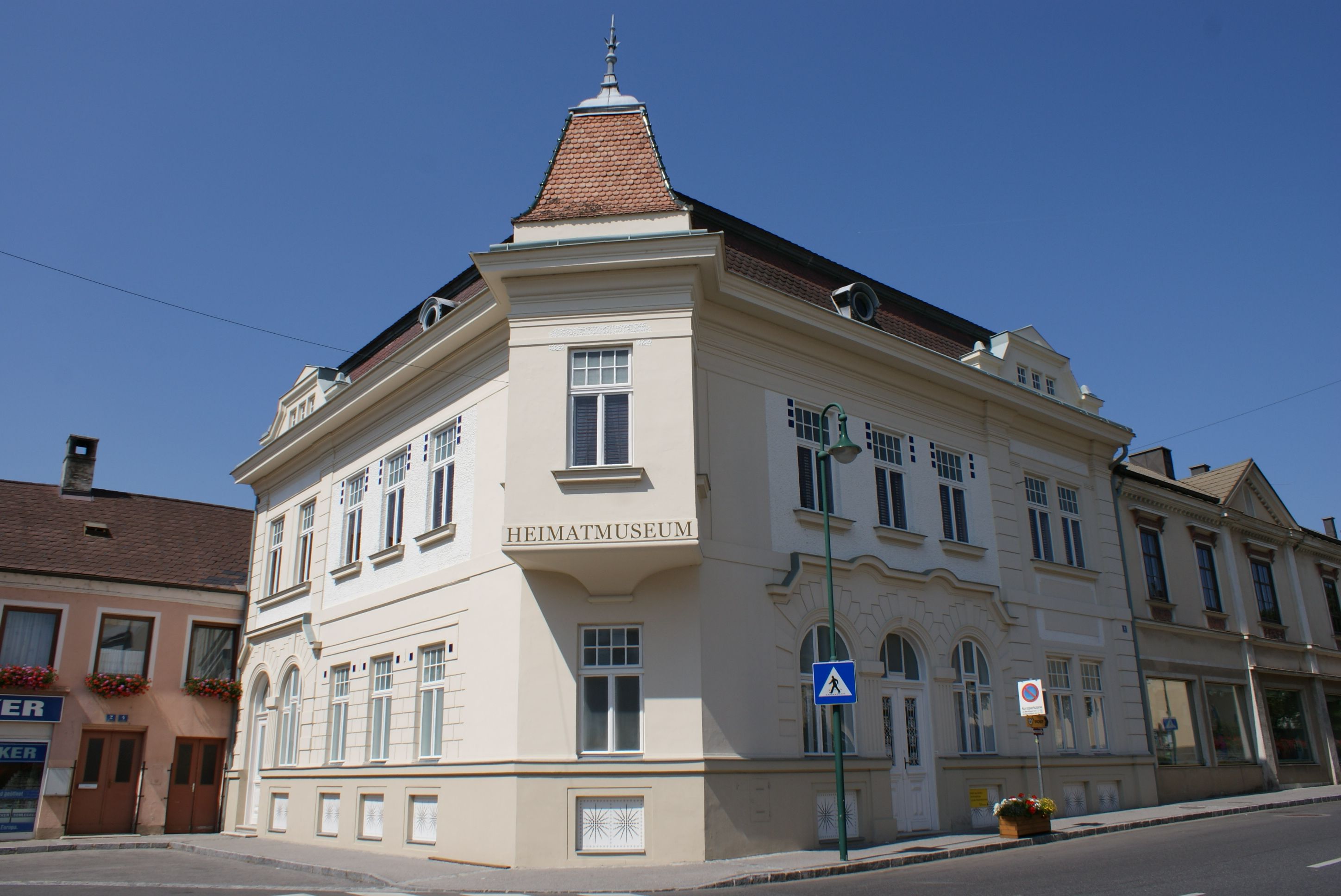 Egy "Heimatmuseum" feliratú történelmi épület az ausztriai Mankban, tiszta ég alatt.