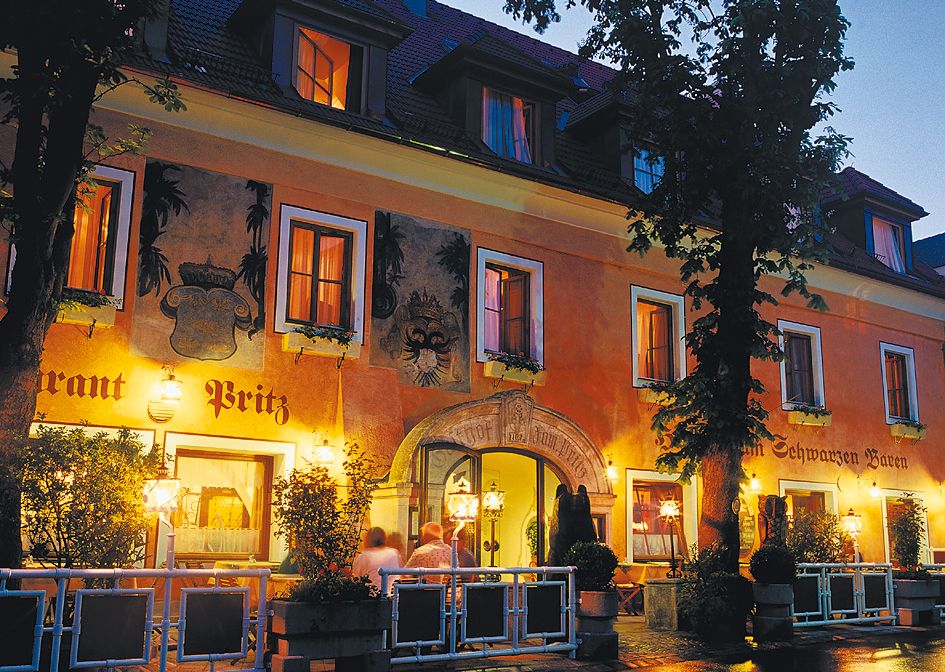 A Hotel Zum Schwarzen Bären történelmi épülete éjszaka, meleg fénnyel megvilágítva.