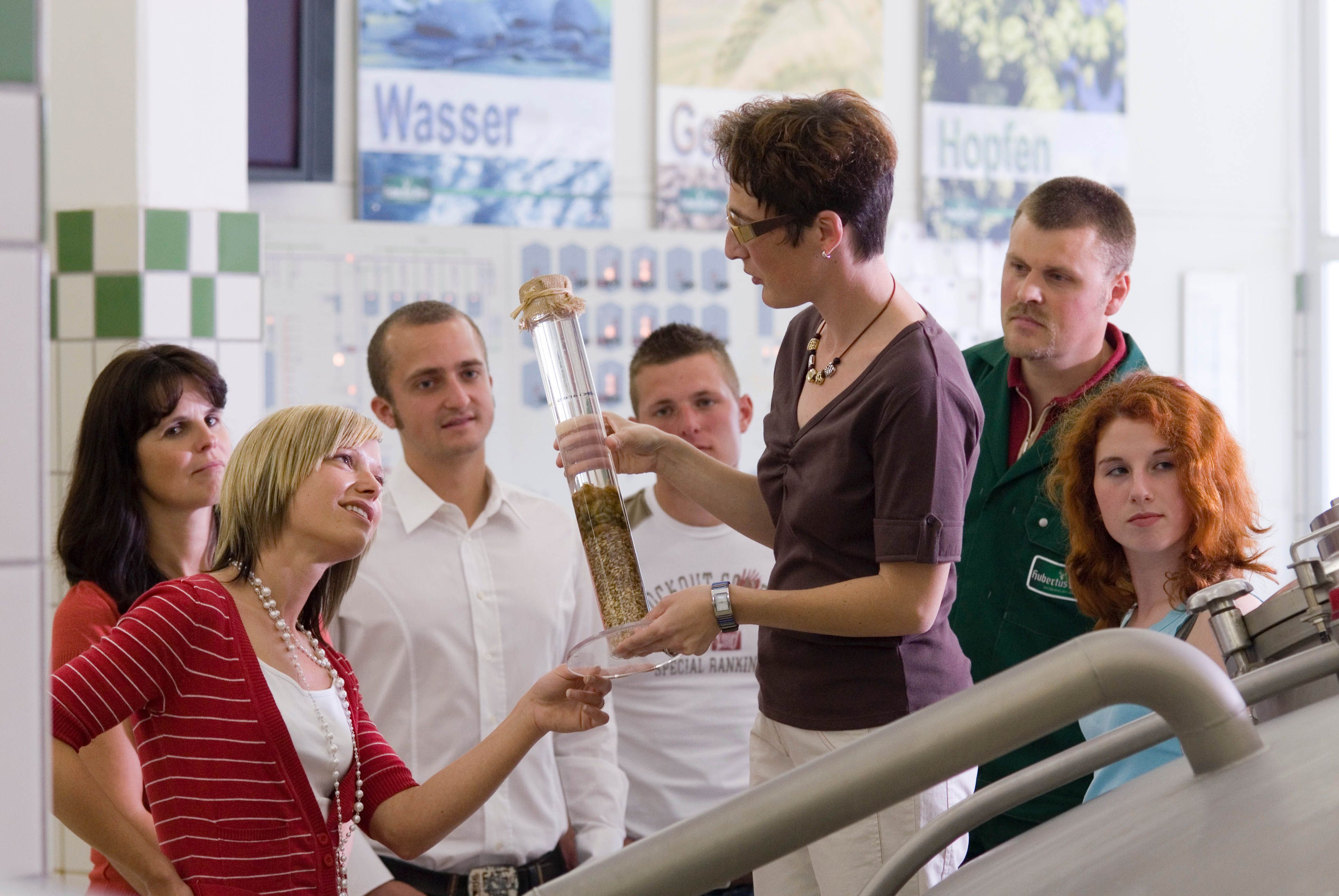 Emberek csoportja egy sörfőzde idegenvezetésén.