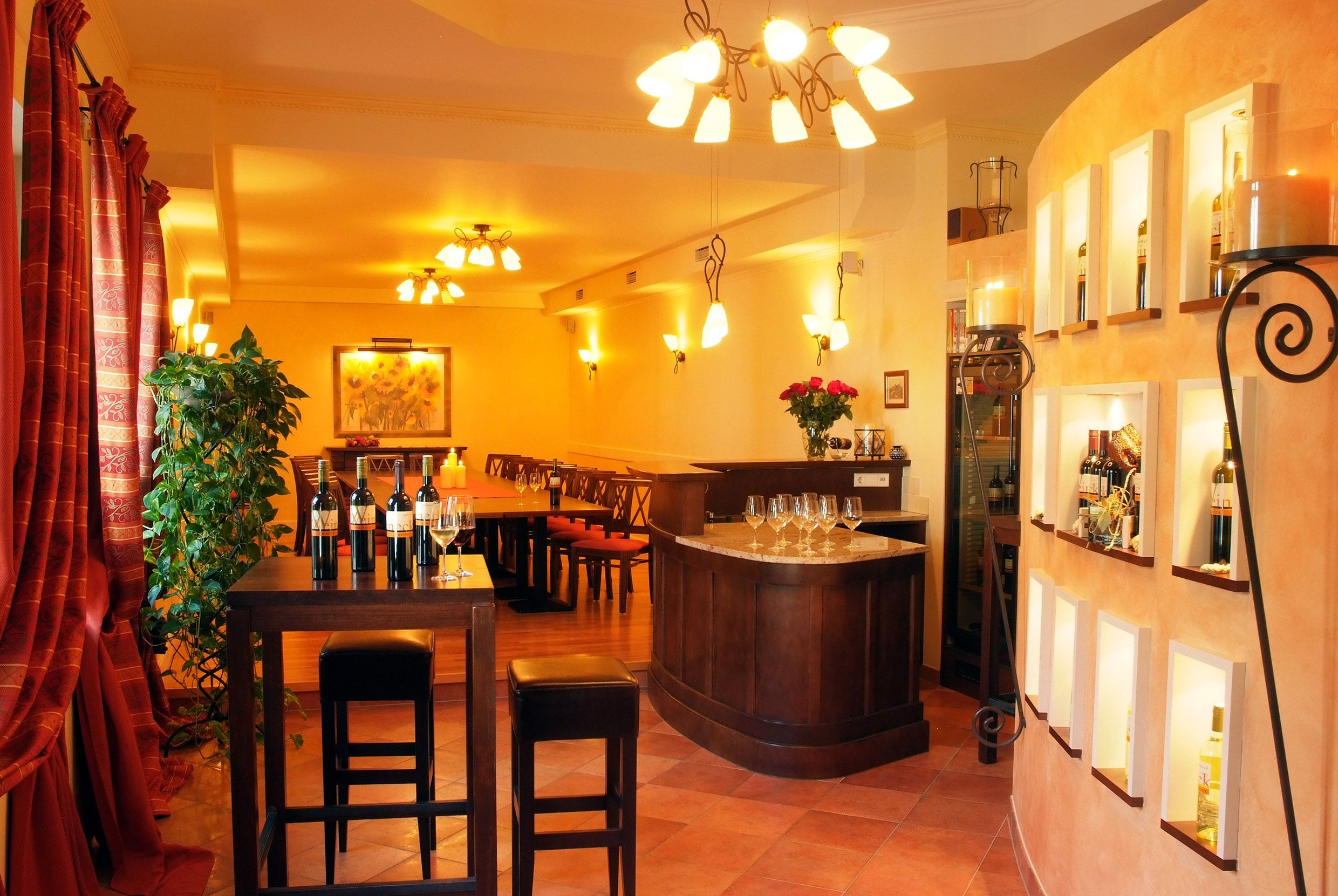 Elegáns kóstolóterem borosüvegekkel, poharakkal és elegáns világítással.