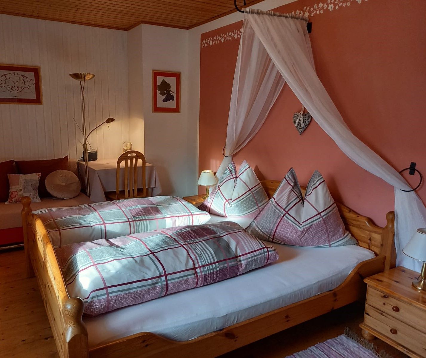 Hangulatos vendégszoba franciaággyal, éjjeli lámpákkal és íróasztallal.