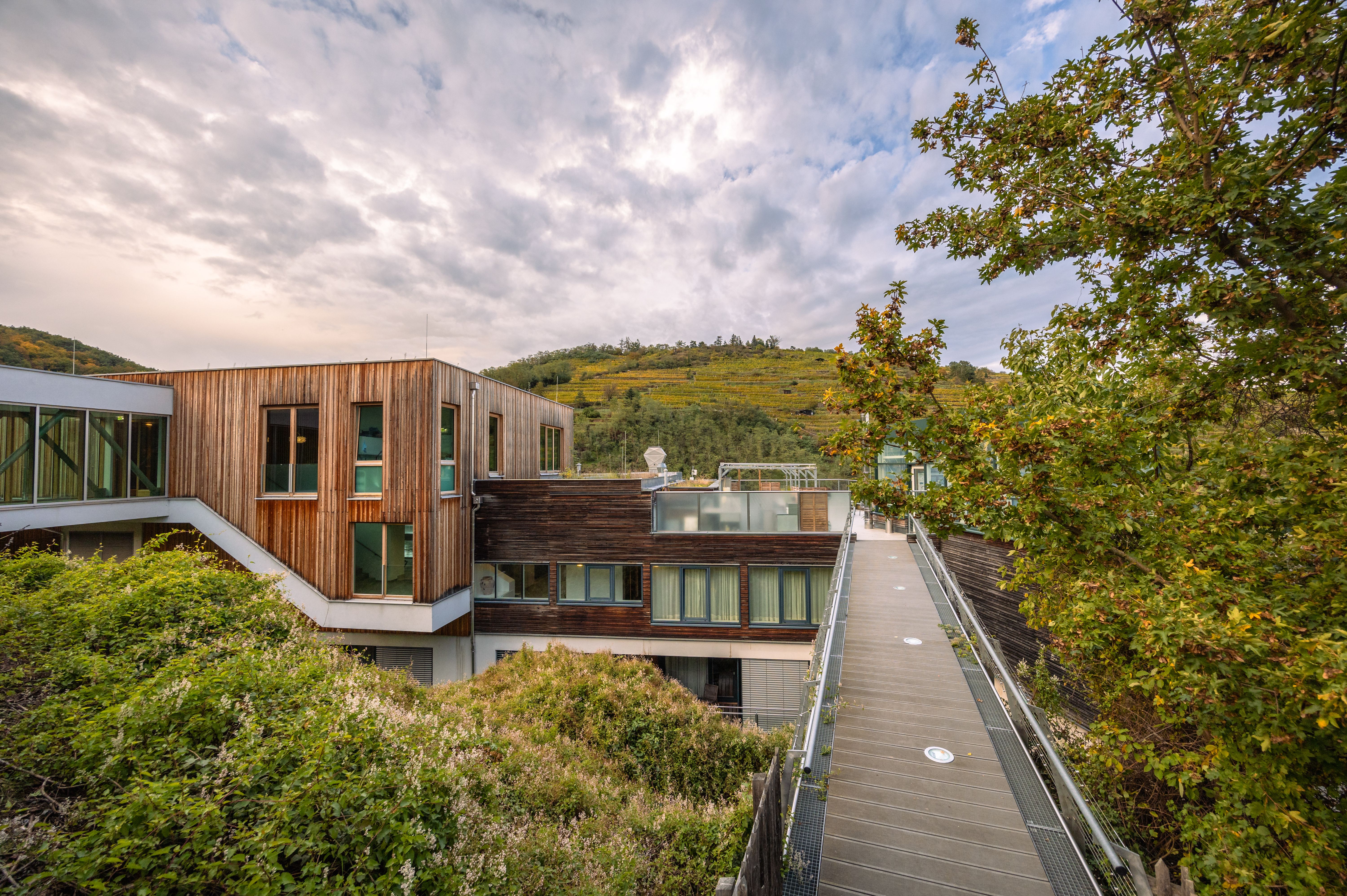 Umgeben von sanften Hügeln und üppigem Grün lädt diese moderne Architektur zum Entspannen ein. Die harmonische Verbindung von Natur und Design schafft eine einladende Atmosphäre, die perfekt für einen erholsamen Aufenthalt ist.