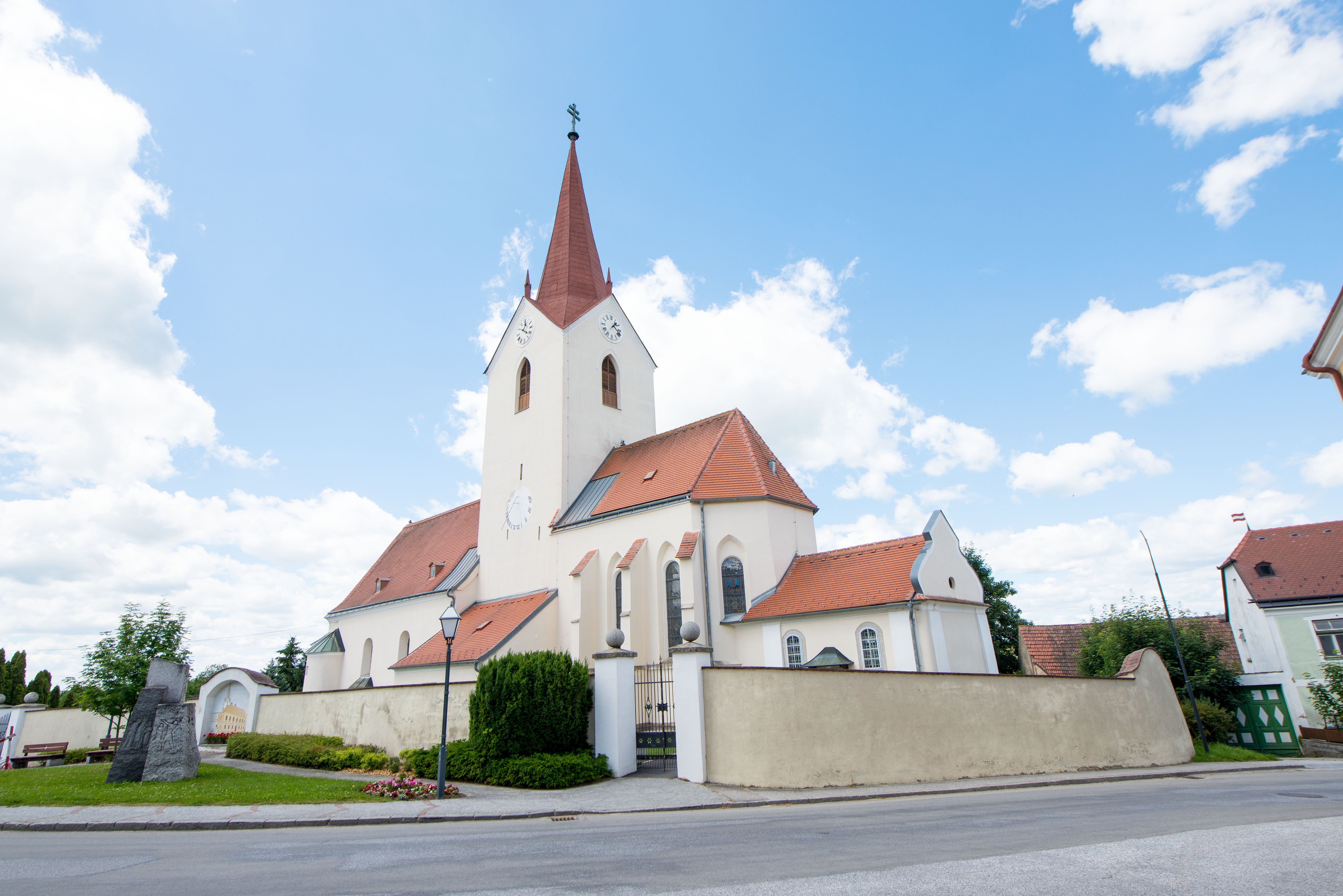 Schweiggersi templom vörös tetővel és toronnyal a kék égbolton.
