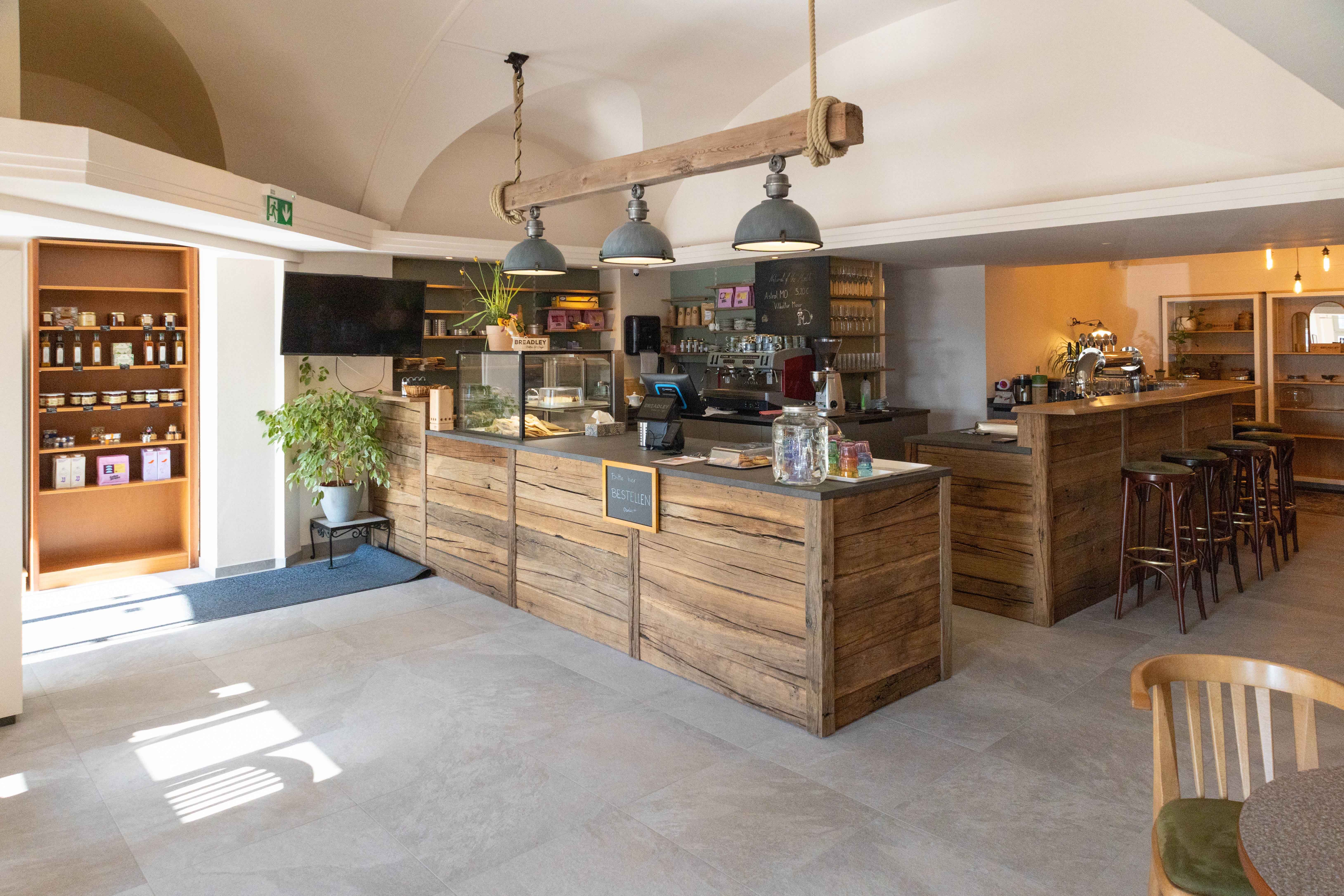 Egy hangulatos kávézó belső nézete, fa bútorokkal és pultokkal.