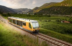 Die Wachaubahn schlängelt sich malerisch durch die sanften Hügel und Weinberge, während die Sonne sanft über die Landschaft strahlt. Die frische Luft und der Duft von blühenden Wiesen laden dazu ein, die Schönheit der Natur zu genießen und die Seele baumeln zu lassen.